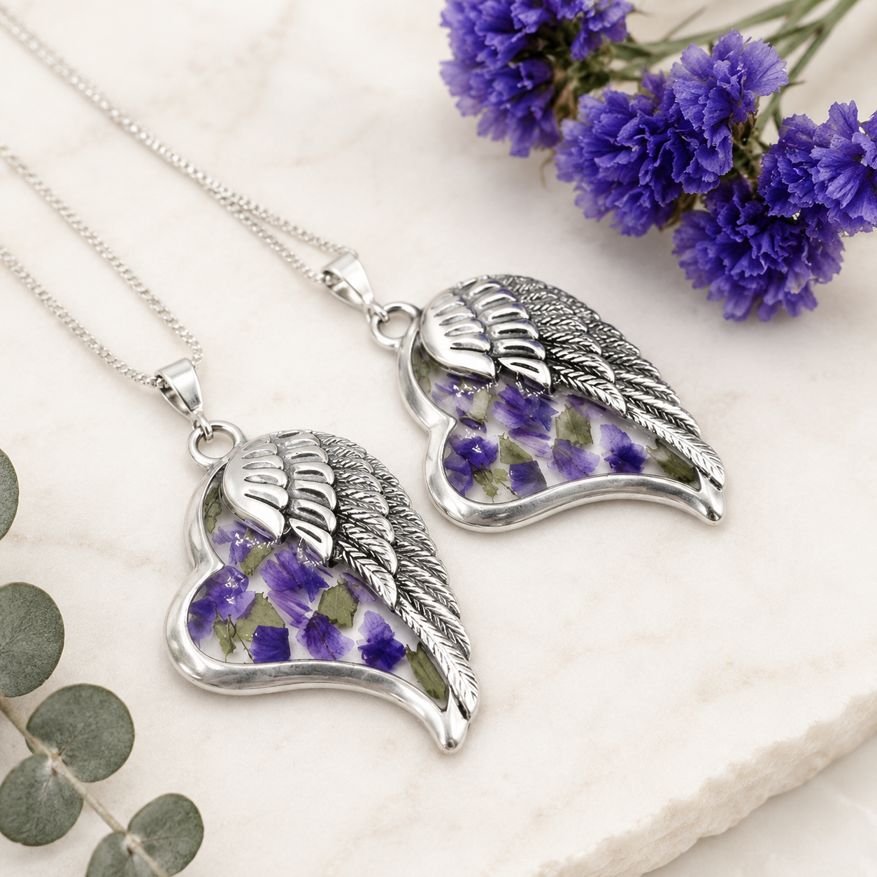 Angel's Embrace Pendant handcrafted in sterling silver with preserved wedding flowers or funeral flowers, creating a custom memorial keepsake necklace with an angel wing design.