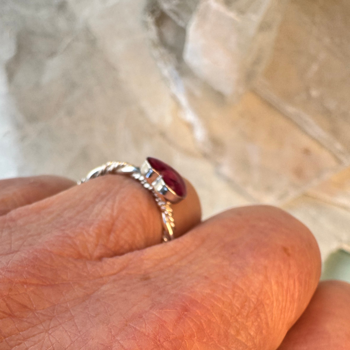 Side profile view of the Beloved Heart Keepsake Ring showing the raised 8mm heart-shaped keepsake setting and sterling silver triple-twist band handcrafted from preserved flowers or cremation ashes.