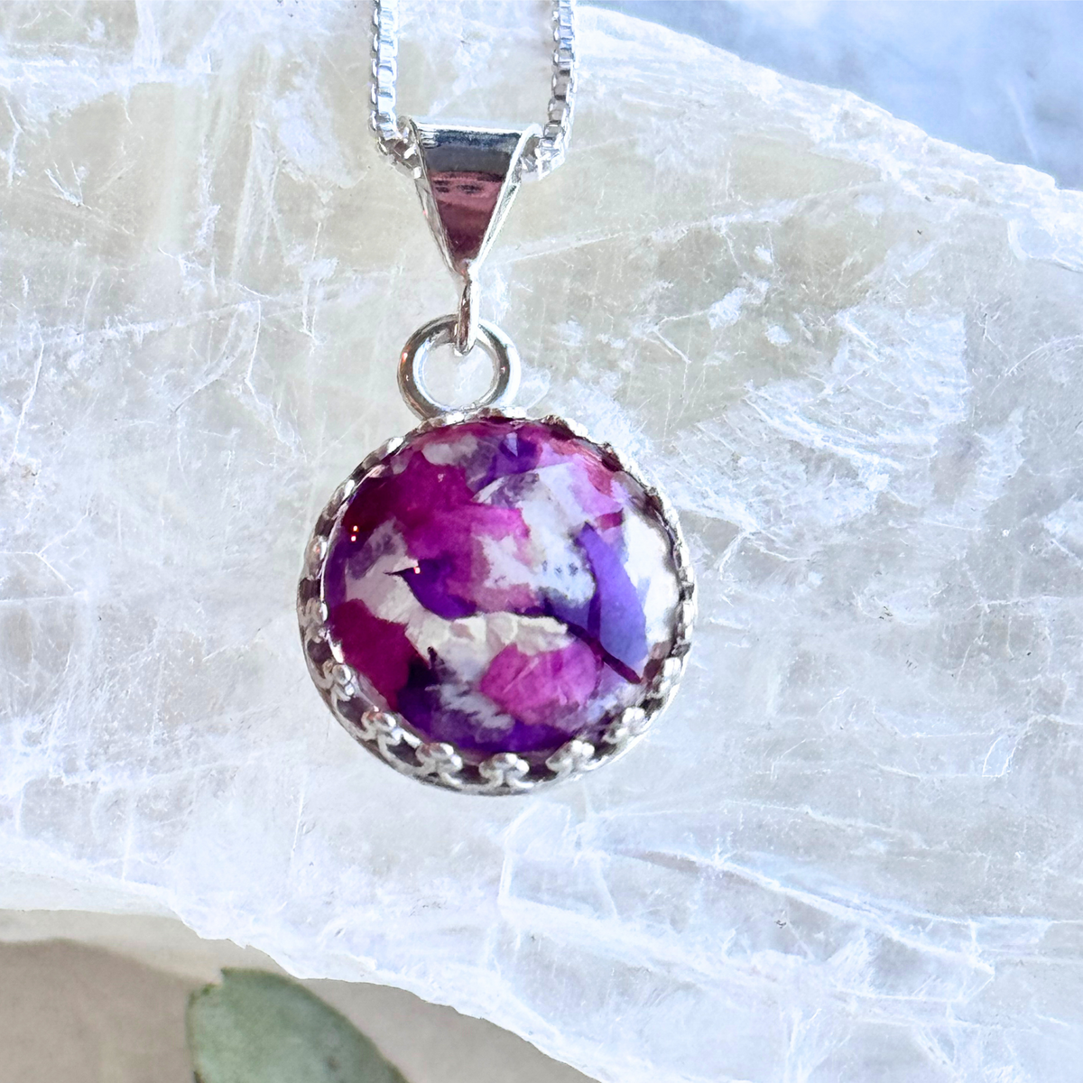 Close-up of round pendant with preserved flowers