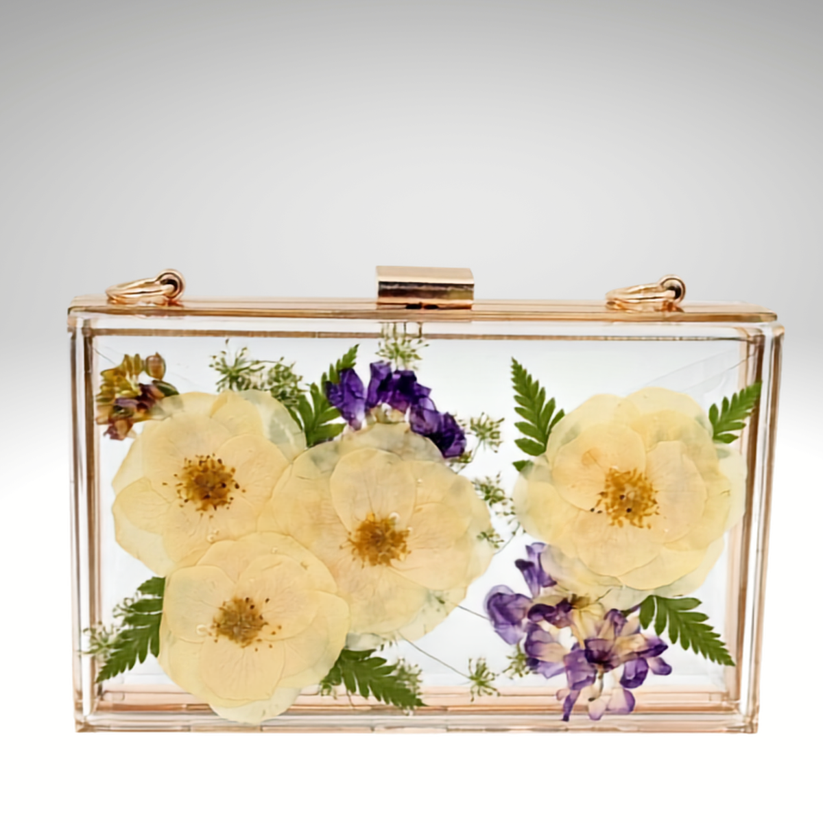 Front view of a custom clear acrylic bridal clutch handcrafted with preserved wedding flowers in resin, featuring ivory roses, purple flowers, and greenery.