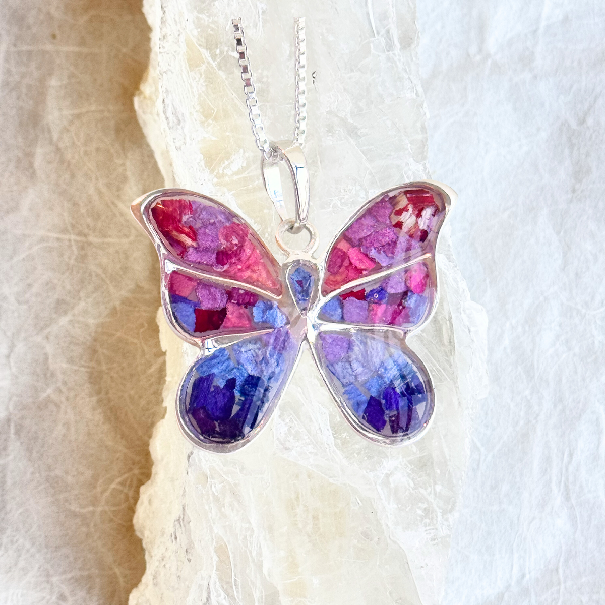 Close-up of the Butterfly Keepsake Pendant highlighting intricate preserved flower details.