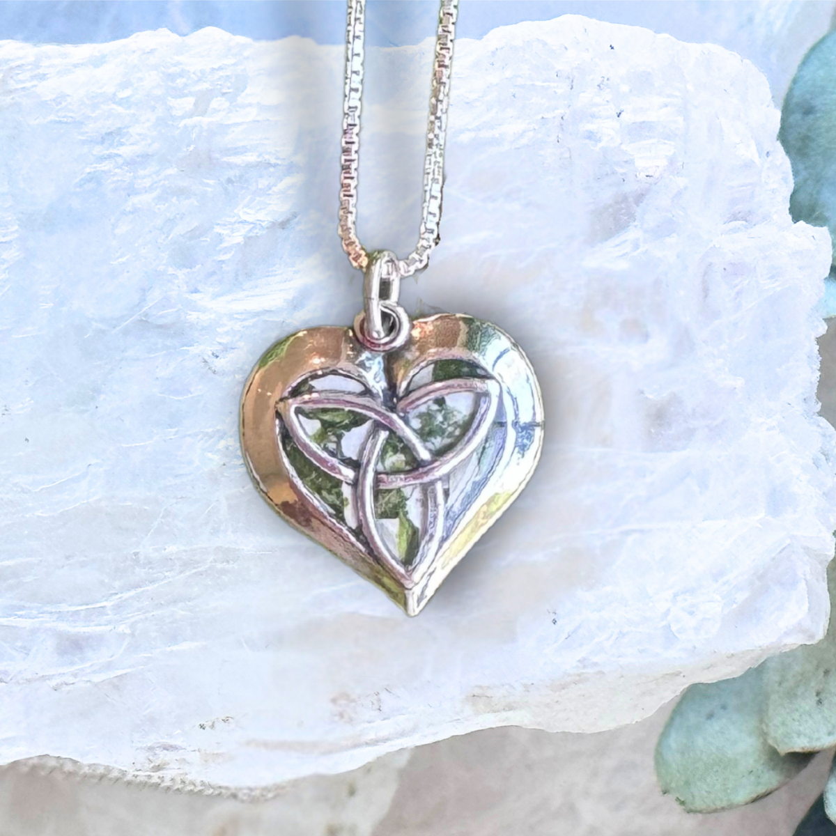 Close-up of the Celtic Heart Keepsake Pendant highlighting detailed preserved flowers and the symbolic Celtic knot pattern.