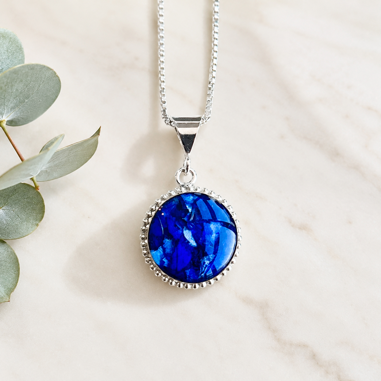 Circle of Memories Pendant handcrafted with preserved blue wedding flowers, memorial flowers, or funeral flowers in a sterling silver custom keepsake necklace.