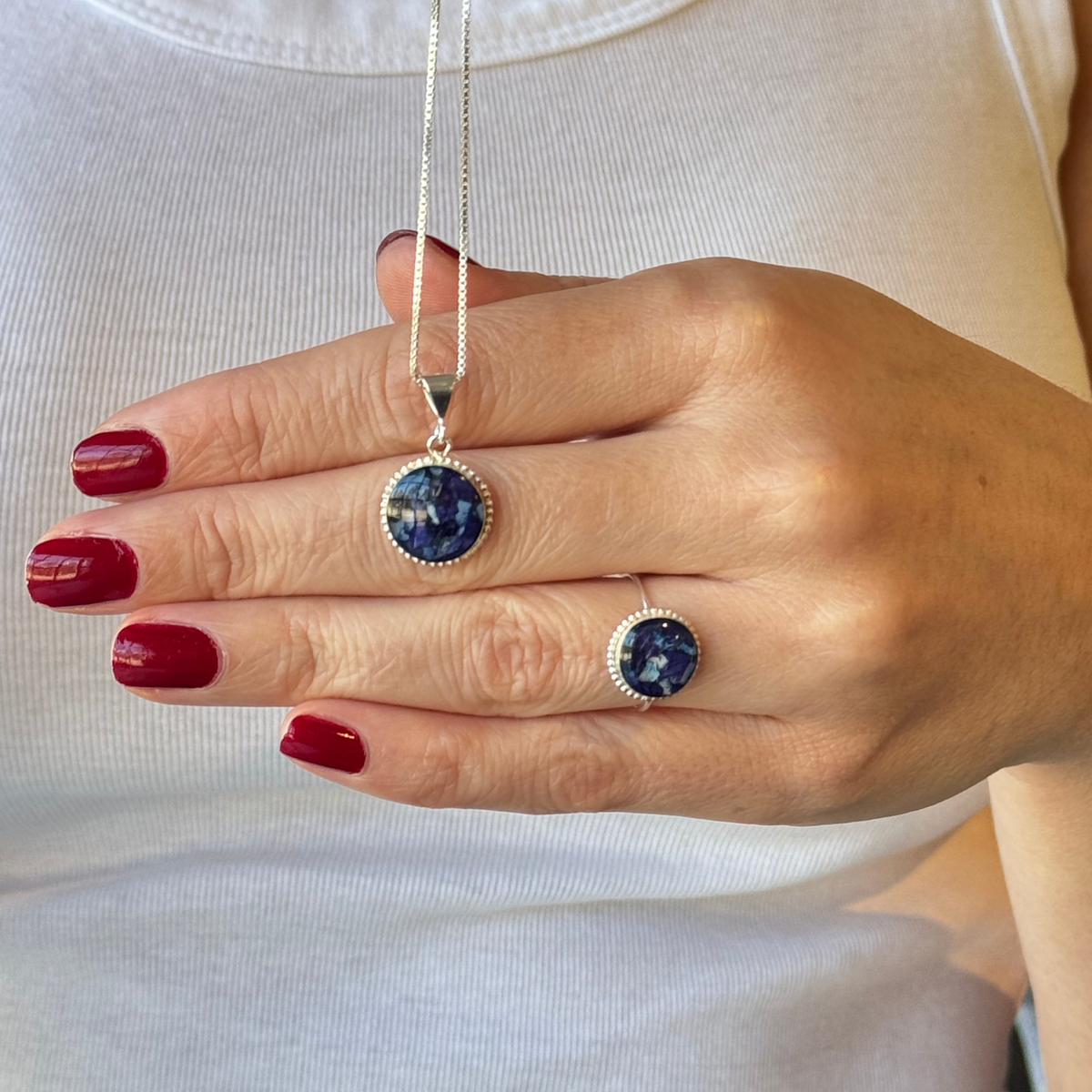 Model wearing the Circle of Memories Pendant with a matching ring, both featuring preserved flowers in sterling silver settings.