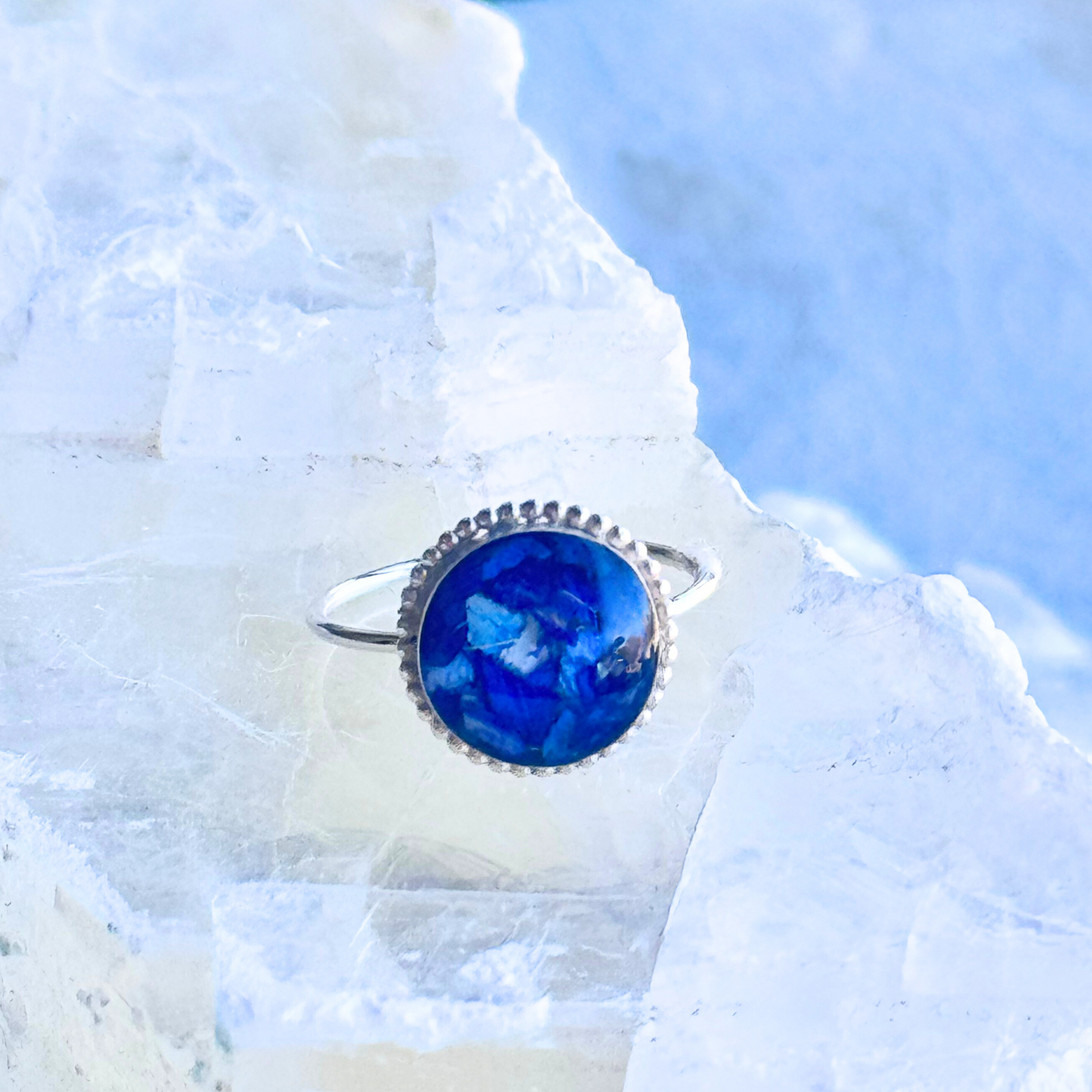A delicate Circle of Memories Ring featuring a handcrafted blue hydrangea-infused stone, symbolizing remembrance and love. Set in a timeless silver band, this memorial jewelry piece preserves cherished moments and honors loved ones.