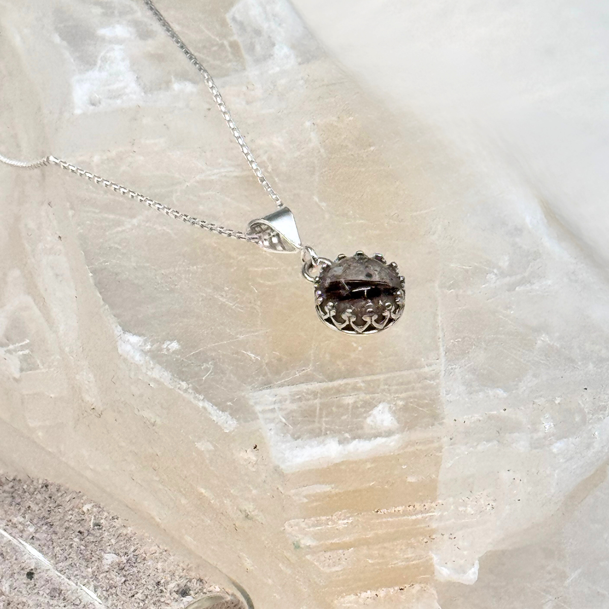 Side view of the Ever Close pet memorial pendant, showing the depth of the resin and the sterling silver filigree setting.