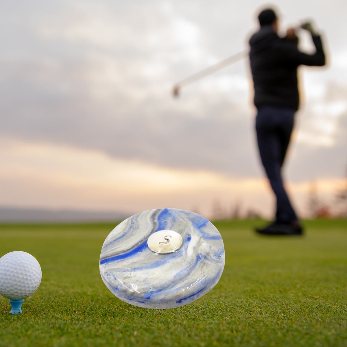 Handmade pet memorial golf ball marker on a golf course. A unique keepsake infused with pet ashes or fur, perfect for golfers honoring a beloved pet.