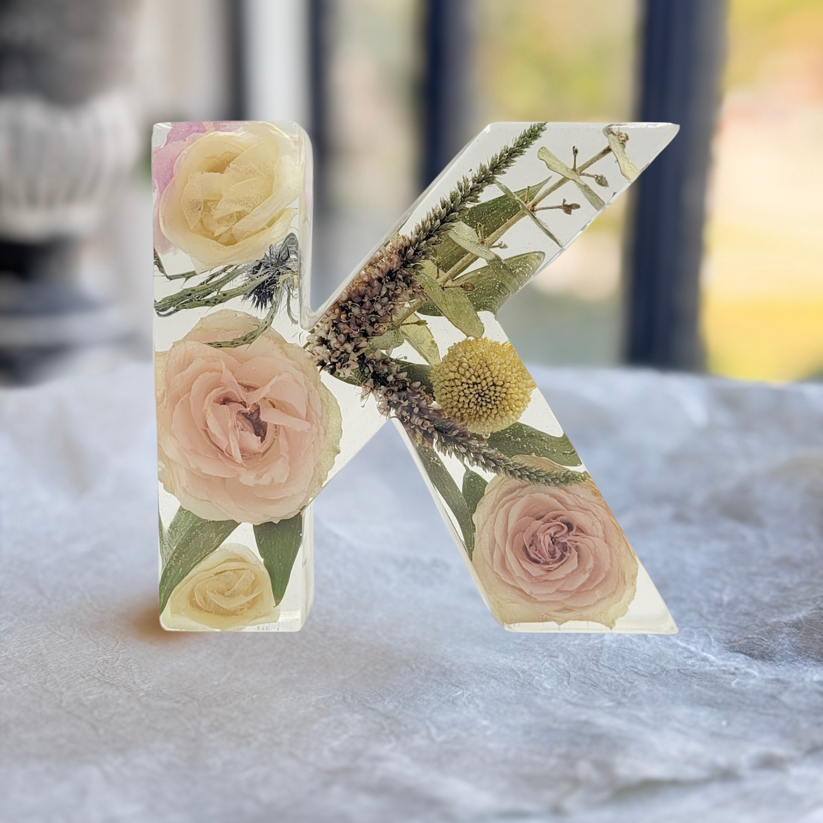 Clear resin letter K with preserved roses and greenery from wedding or memorial bouquet, handmade floral keepsake