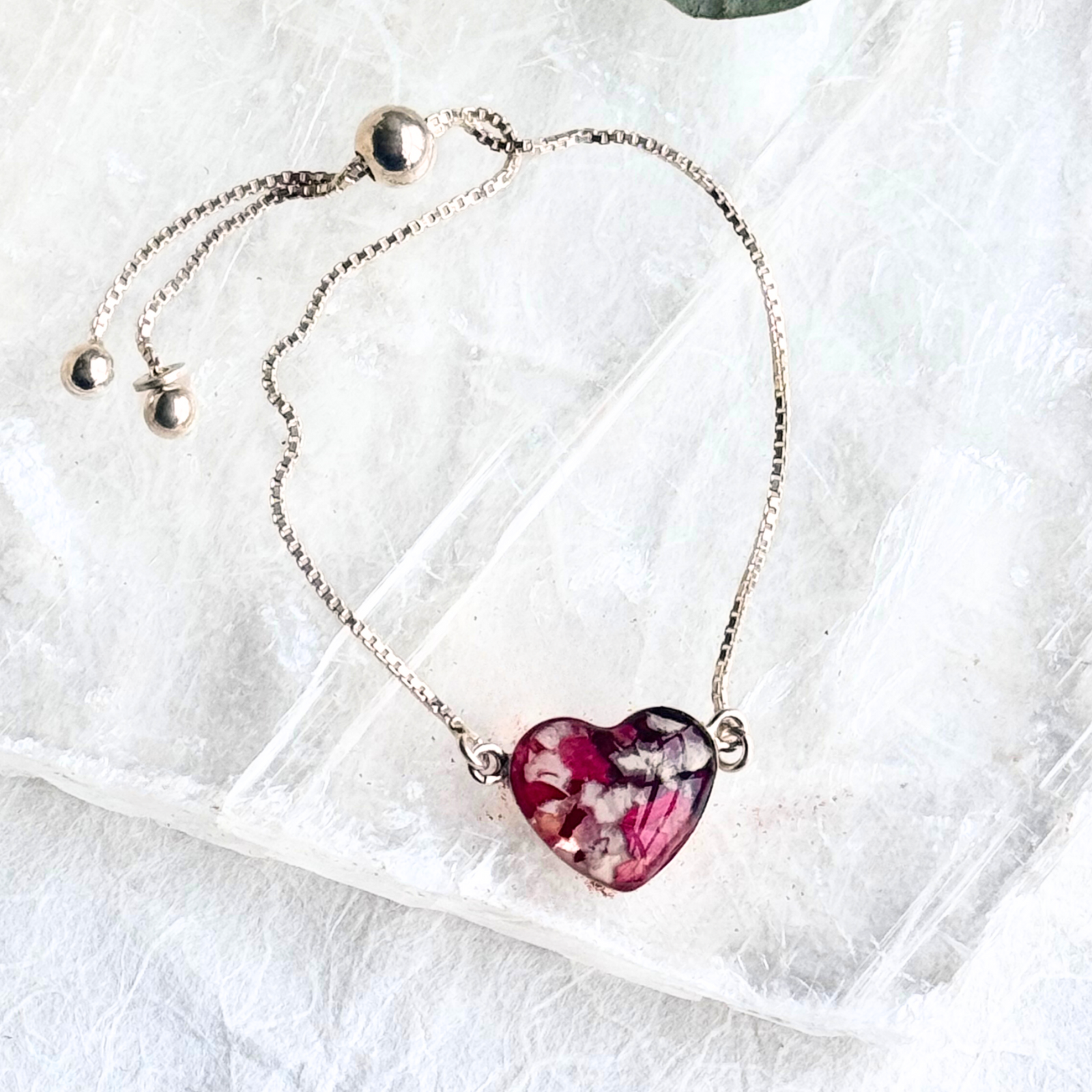 A heart-shaped pendant infused with preserved funeral flowers, set on an adjustable sterling silver chain for a timeless keepsake.