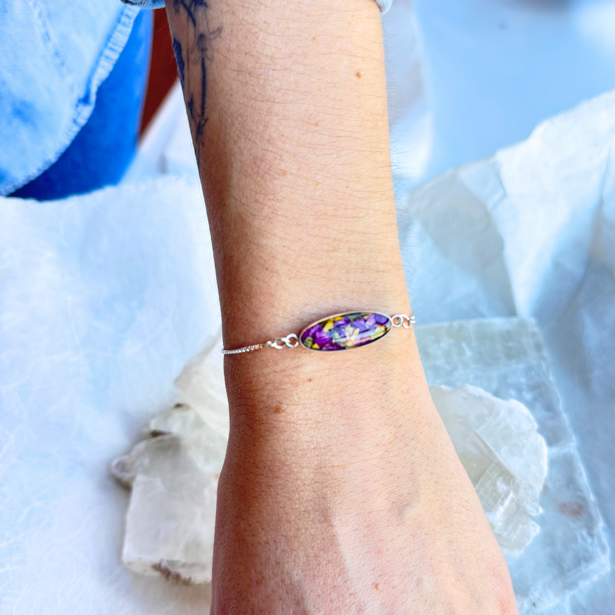  A model wearing the Eternal Grace Memorial Bracelet, showcasing its sterling silver chain and preserved flower bead.