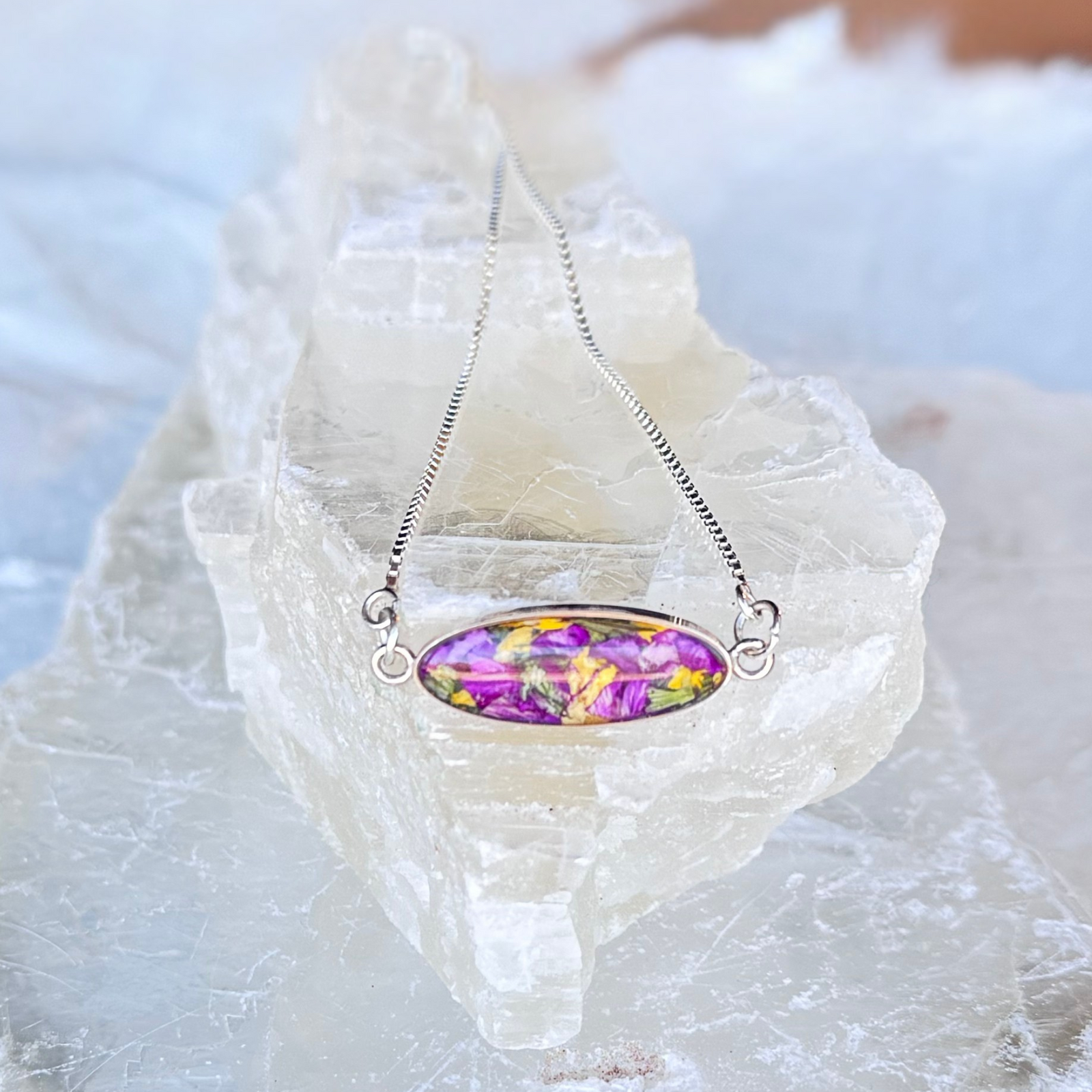  A sterling silver memorial bracelet with a funeral flower-infused bead and an adjustable chain, honoring cherished memories.