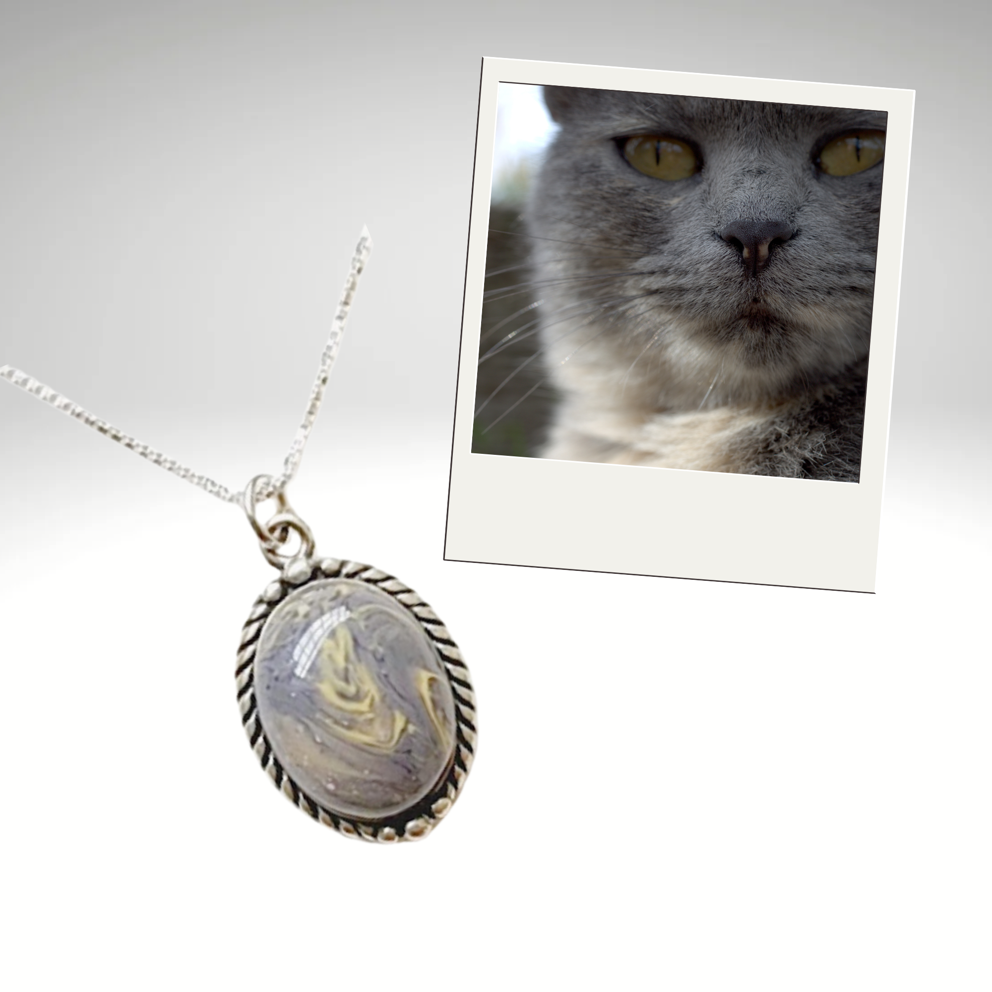 Sterling silver oval pet memorial pendant made with your pet’s ashes or fur, shown with a photo of a gray cat. Personalized cremation necklace keepsake handcrafted to honor your beloved pet.