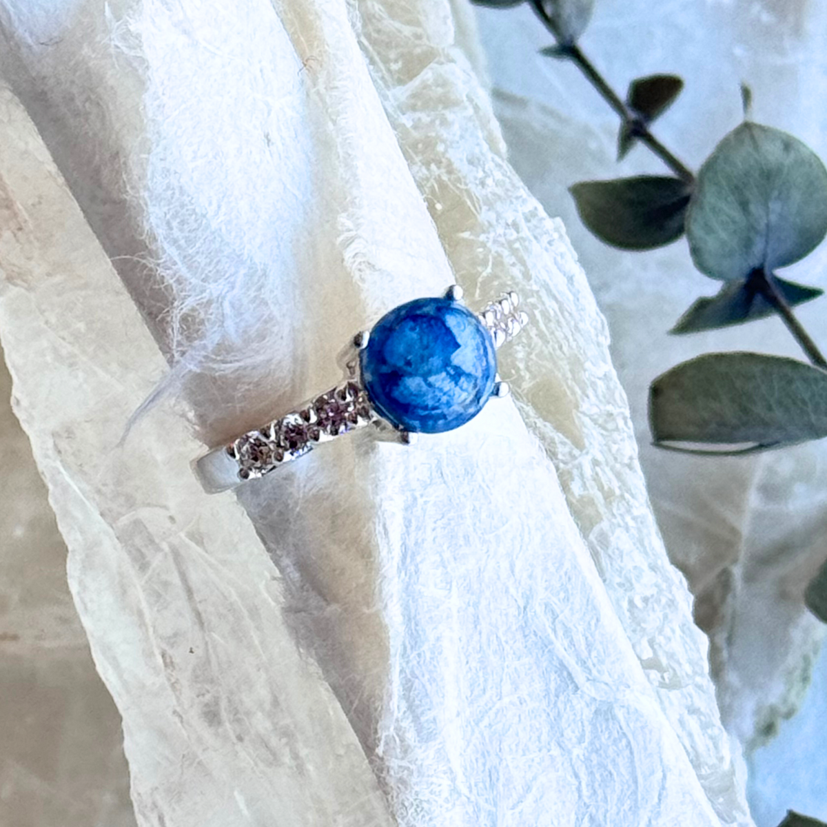 A detailed close-up of the Eternity Bloom Memorial Ring, showcasing its sparkling cubic zirconia side stones and a handcrafted centerpiece infused with preserved flowers. This exquisite memorial jewelry piece beautifully combines elegance and sentimentality.