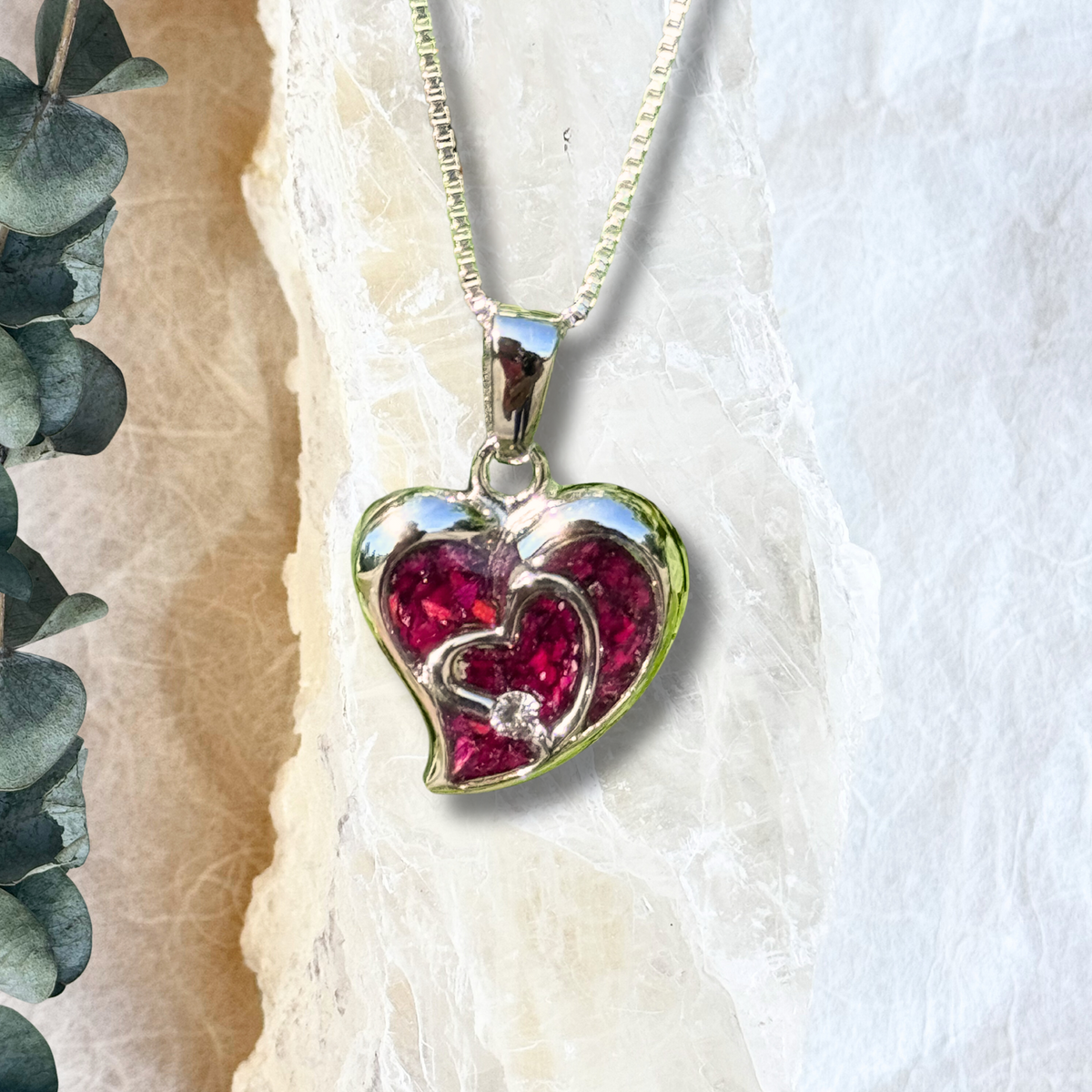 Close-up of the Everlasting Heart Pendant highlighting the intricate details of the preserved flowers.