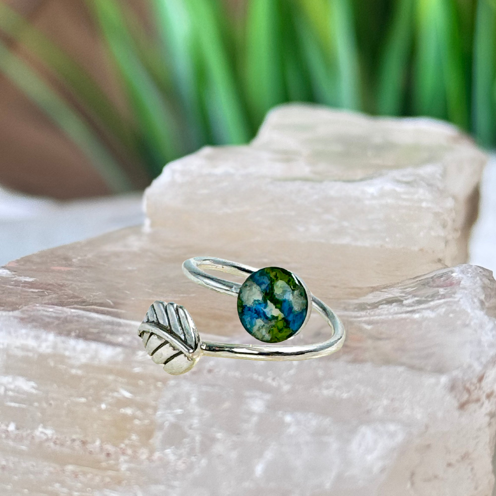 Everleaf Keepsake Ring crafted in sterling silver with an 8mm keepsake setting featuring preserved blue, white, and green flower petals. A handcrafted flower preservation ring created from wedding flowers, funeral flowers, cremation ashes, or pet fur.