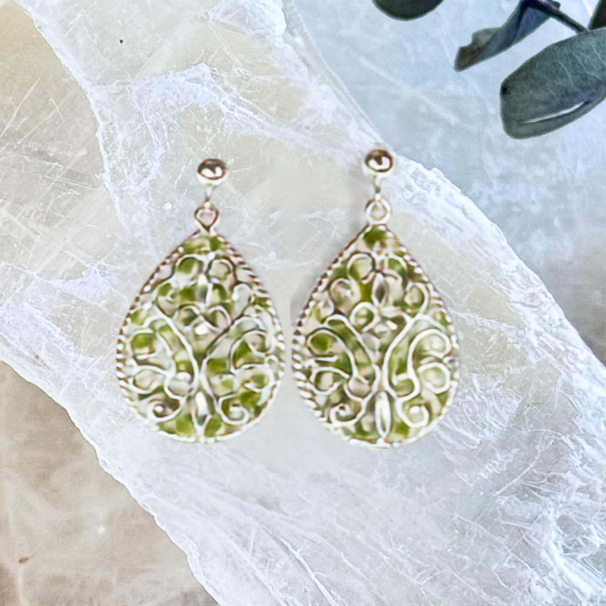 Front view of Floral Keepsake Earrings handcrafted with preserved flowers in sterling silver teardrop settings featuring intricate scrollwork.