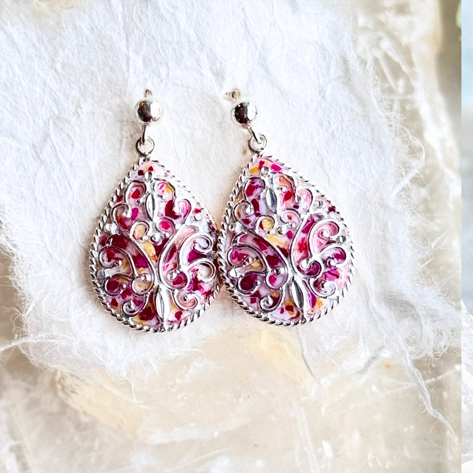 Front view of Floral Keepsake Earrings handcrafted with preserved flowers in a sterling silver teardrop frame with scrollwork detail.