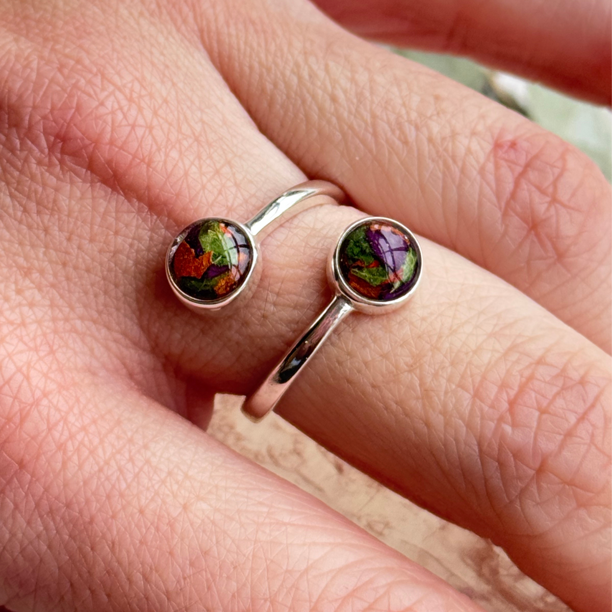 Model wearing the Forever Grace Ring with preserved flowers in shades of purple, orange, and green, crafted into an elegant keepsake.

