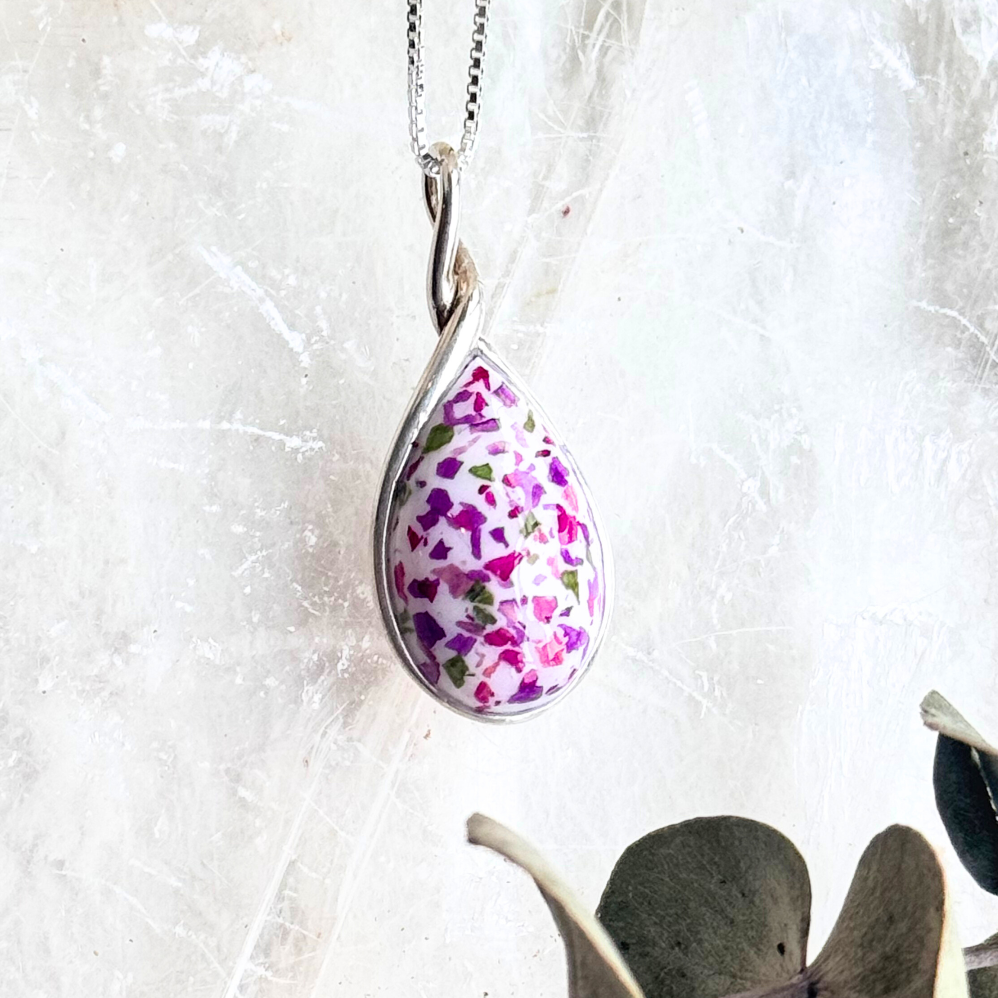 Detailed close-up of the Forever Bloom Pendant highlighting the preserved flowers within the sterling silver teardrop design.