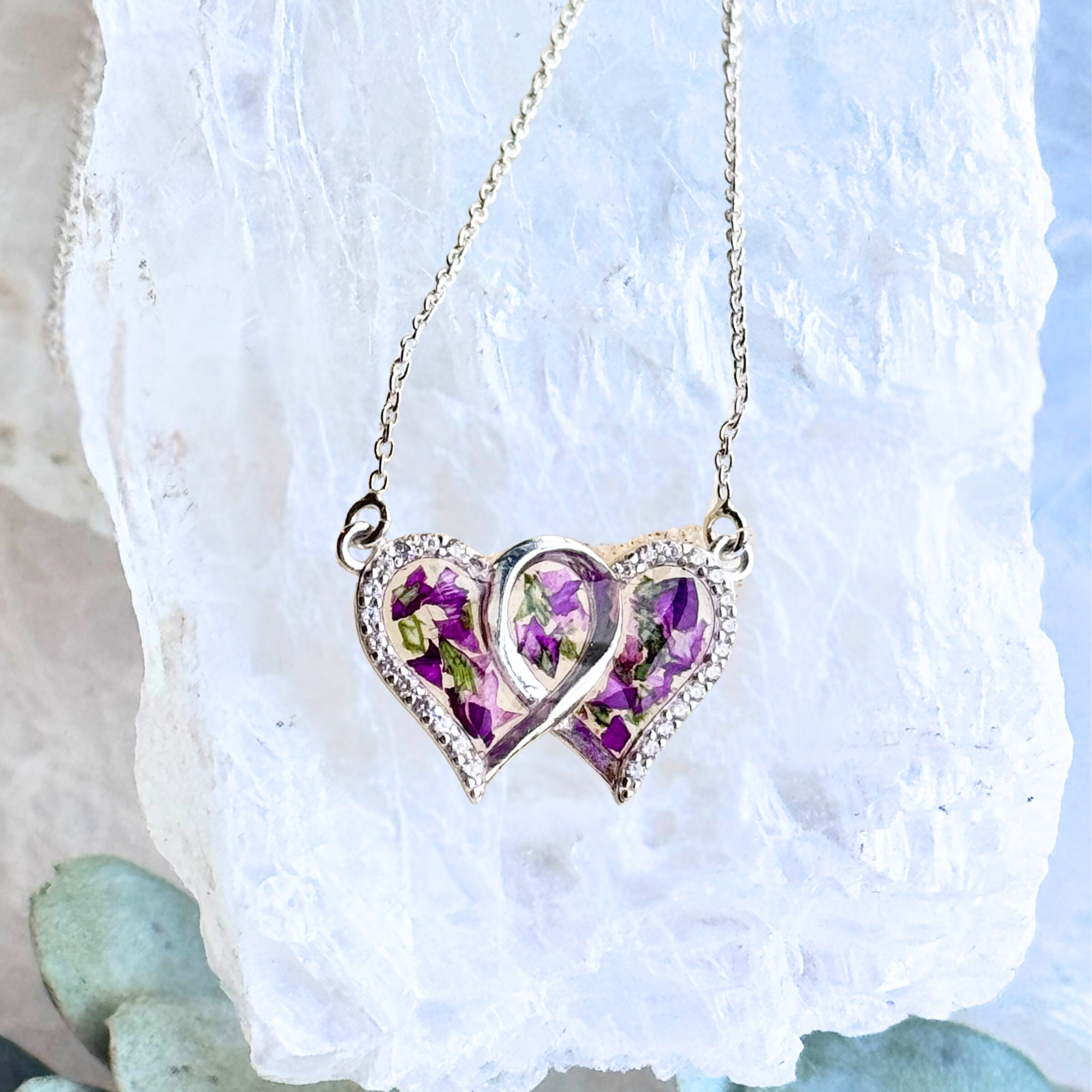 Infinity Heart Pendant with preserved flowers, featuring two intertwined hearts and delicate CZ accents.