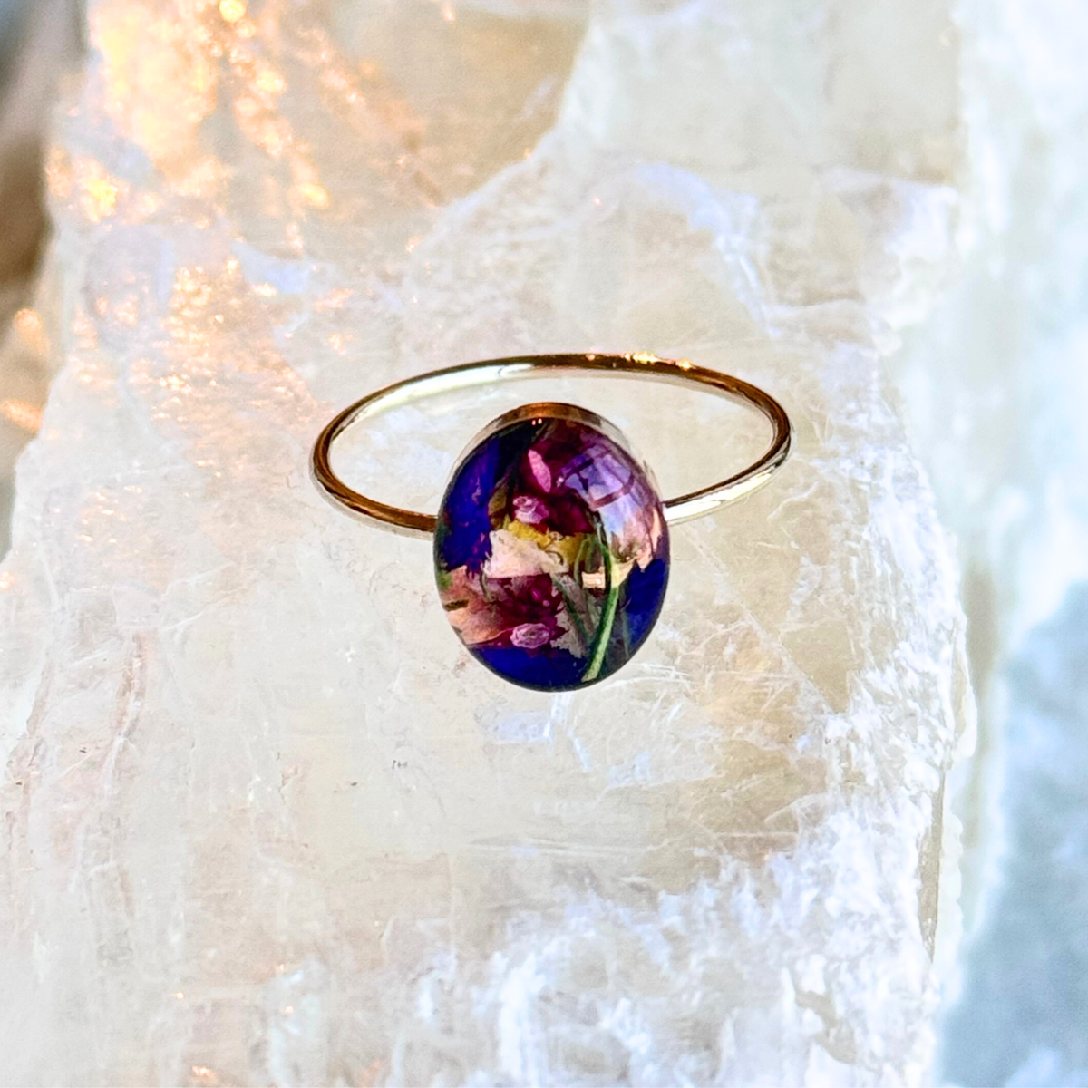 Close-up of the Luna Bloom Ring featuring a handcrafted oval keepsake setting created from preserved flowers and set in a gold-filled band.