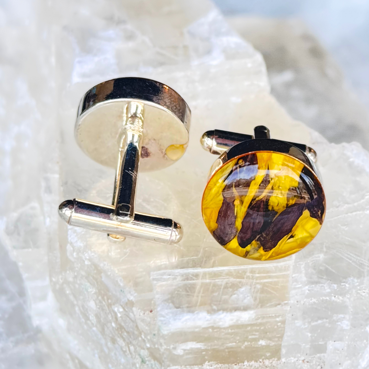 A pair of handcrafted memorial cufflinks infused with preserved funeral flowers and ashes, set in high-quality metal hardware.