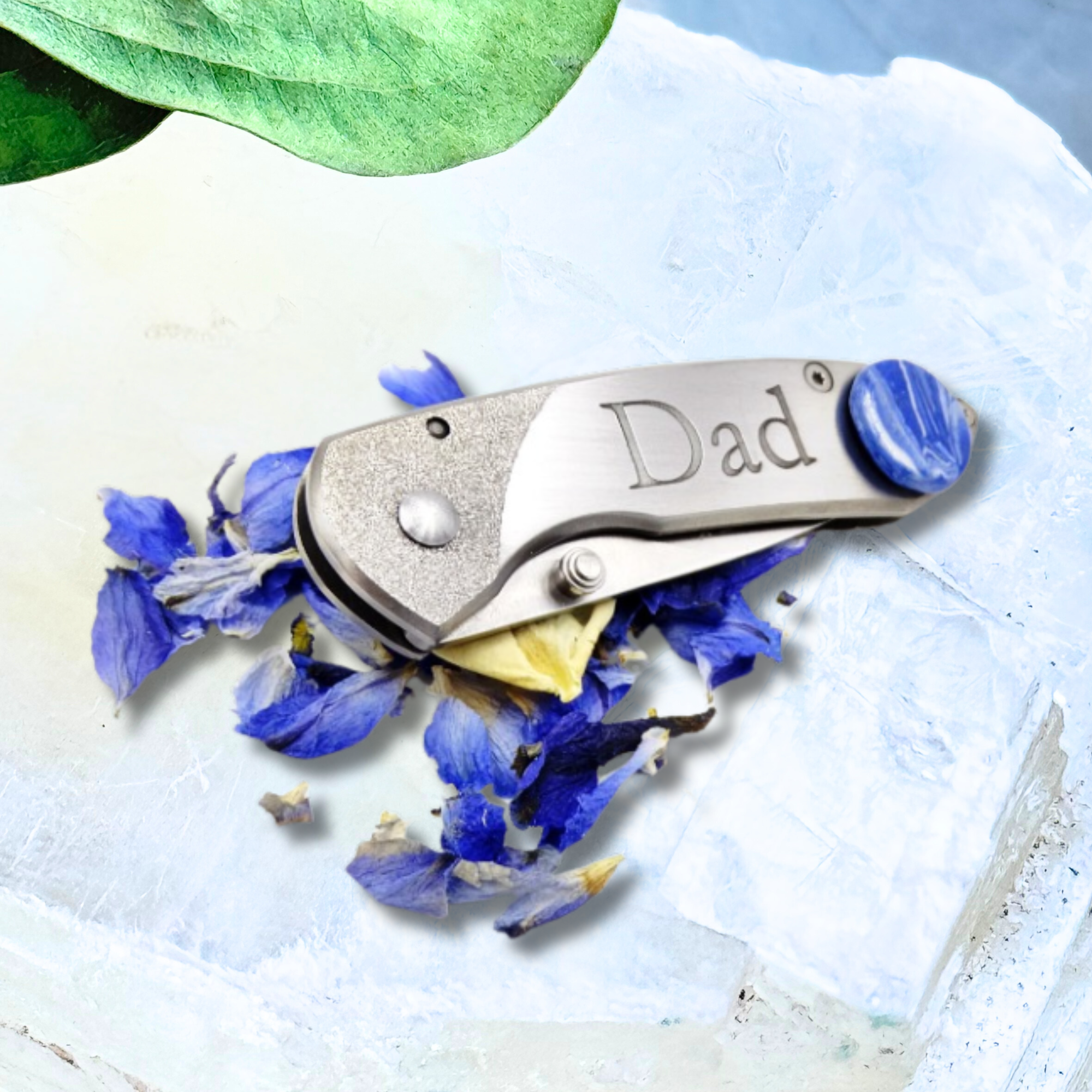 A stainless steel memorial pocket knife featuring an 18mm floral inlay with preserved funeral flowers and custom engraving.