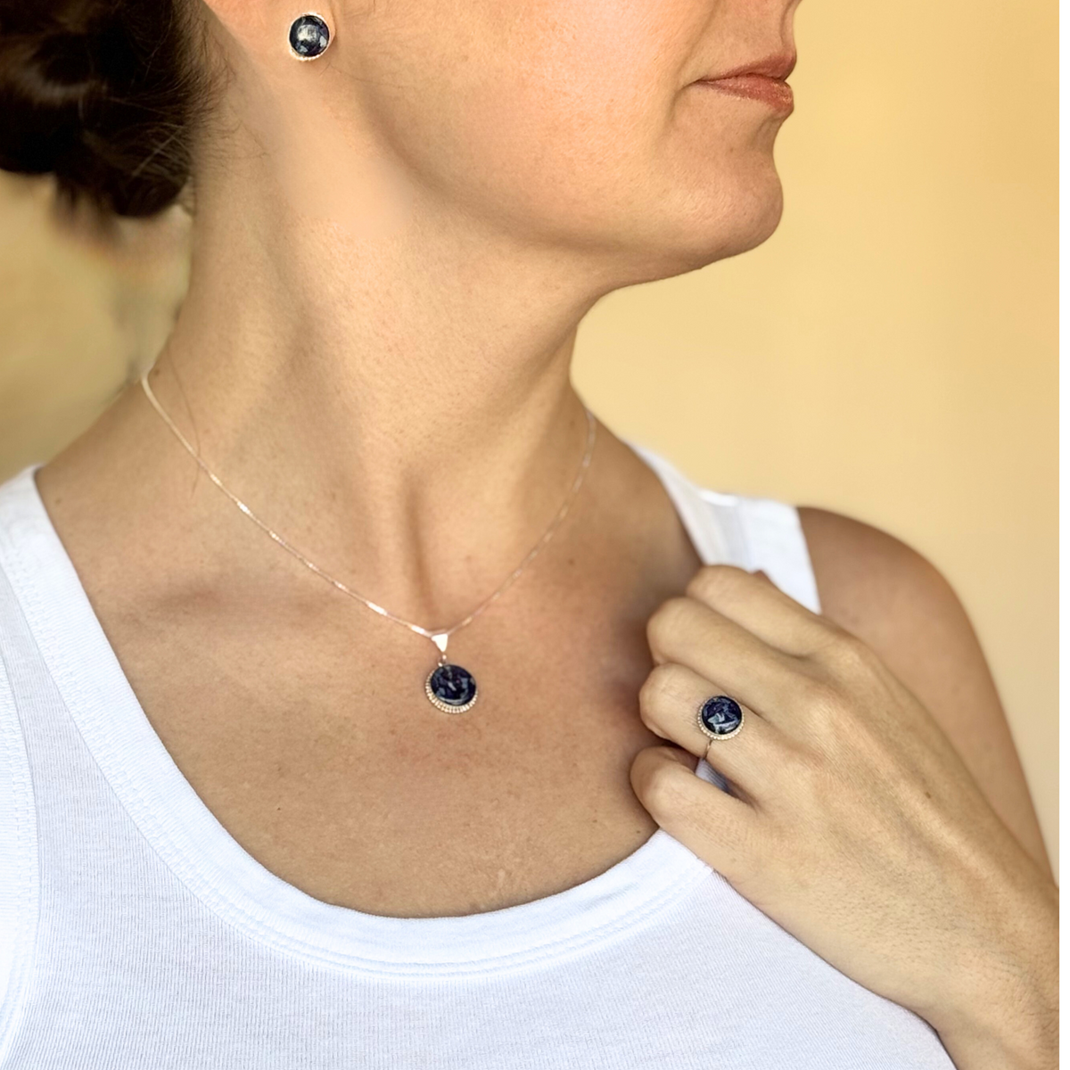 Model wearing the Circle of Memories Pendant, earrings, and ring, all crafted with preserved flowers in sterling silver.