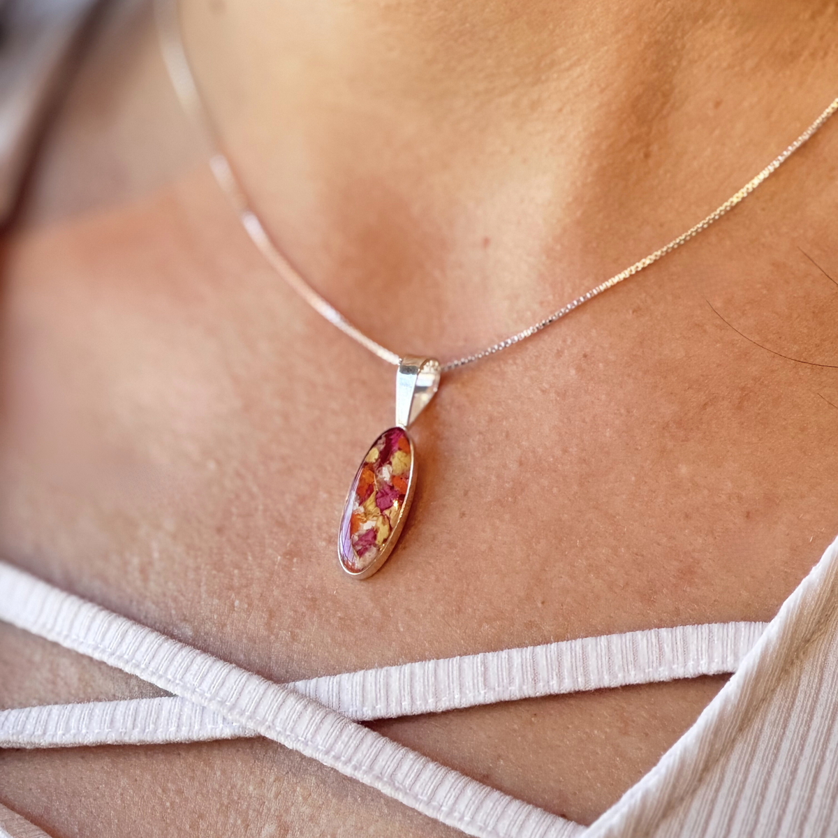 Model wearing the Eternal Grace Pendant, featuring preserved flowers in an elegant sterling silver setting.