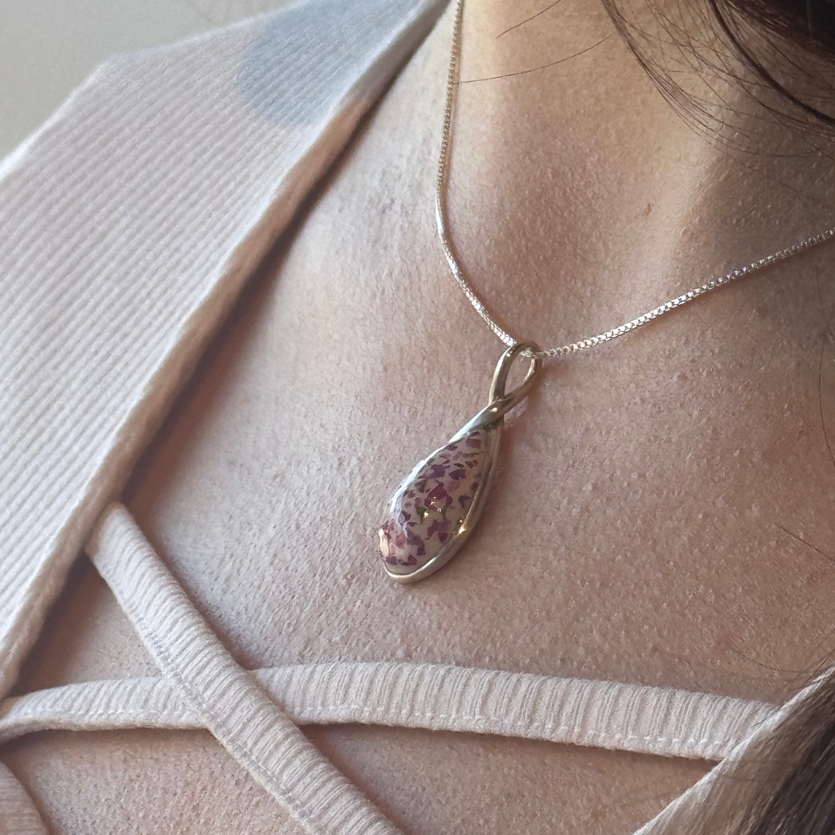 Model wearing the Forever Bloom Pendant, featuring preserved flowers in a sterling silver setting.