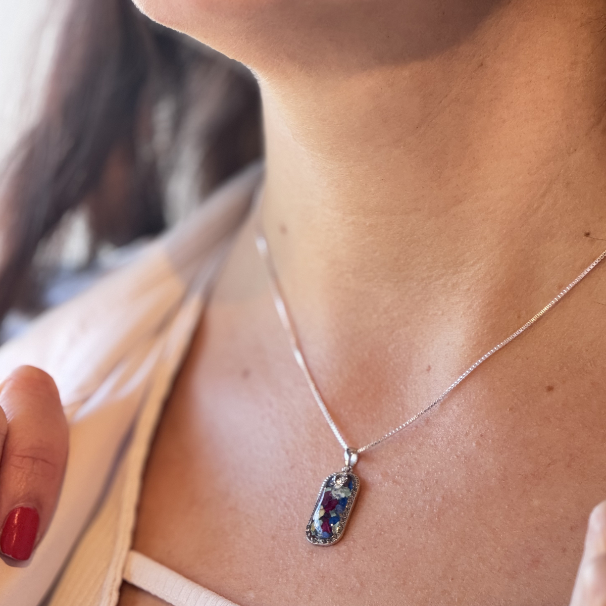 Model wearing the Graceful Remembrance Pendant, featuring preserved flowers and a CZ accent in an elegant sterling silver setting.