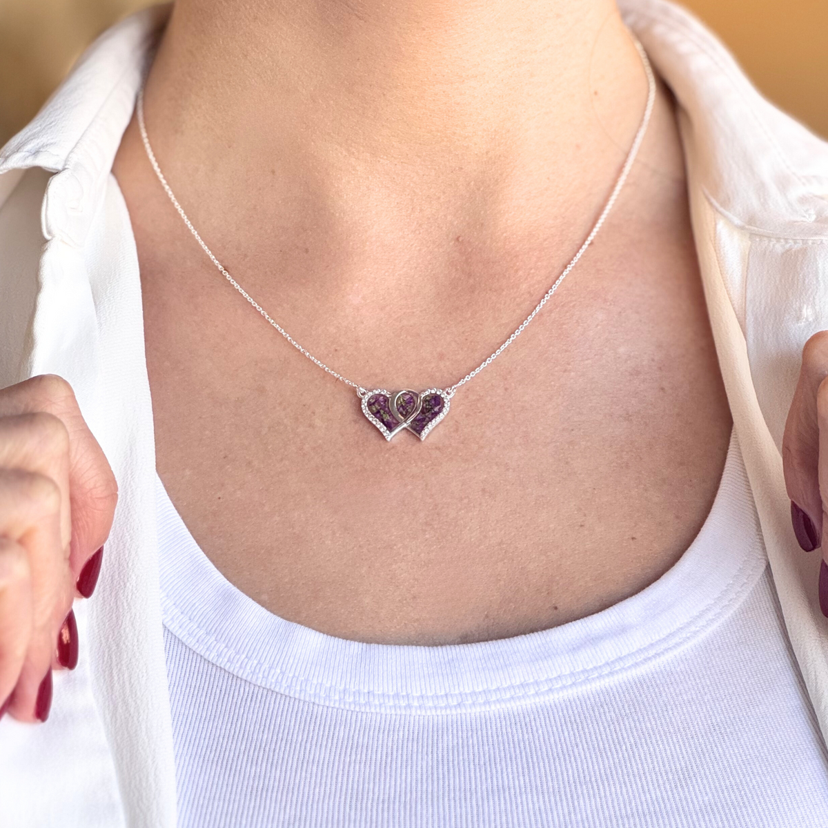 Model wearing the Infinity Heart Pendant, crafted from preserved flowers with CZ accents, symbolizing everlasting love.