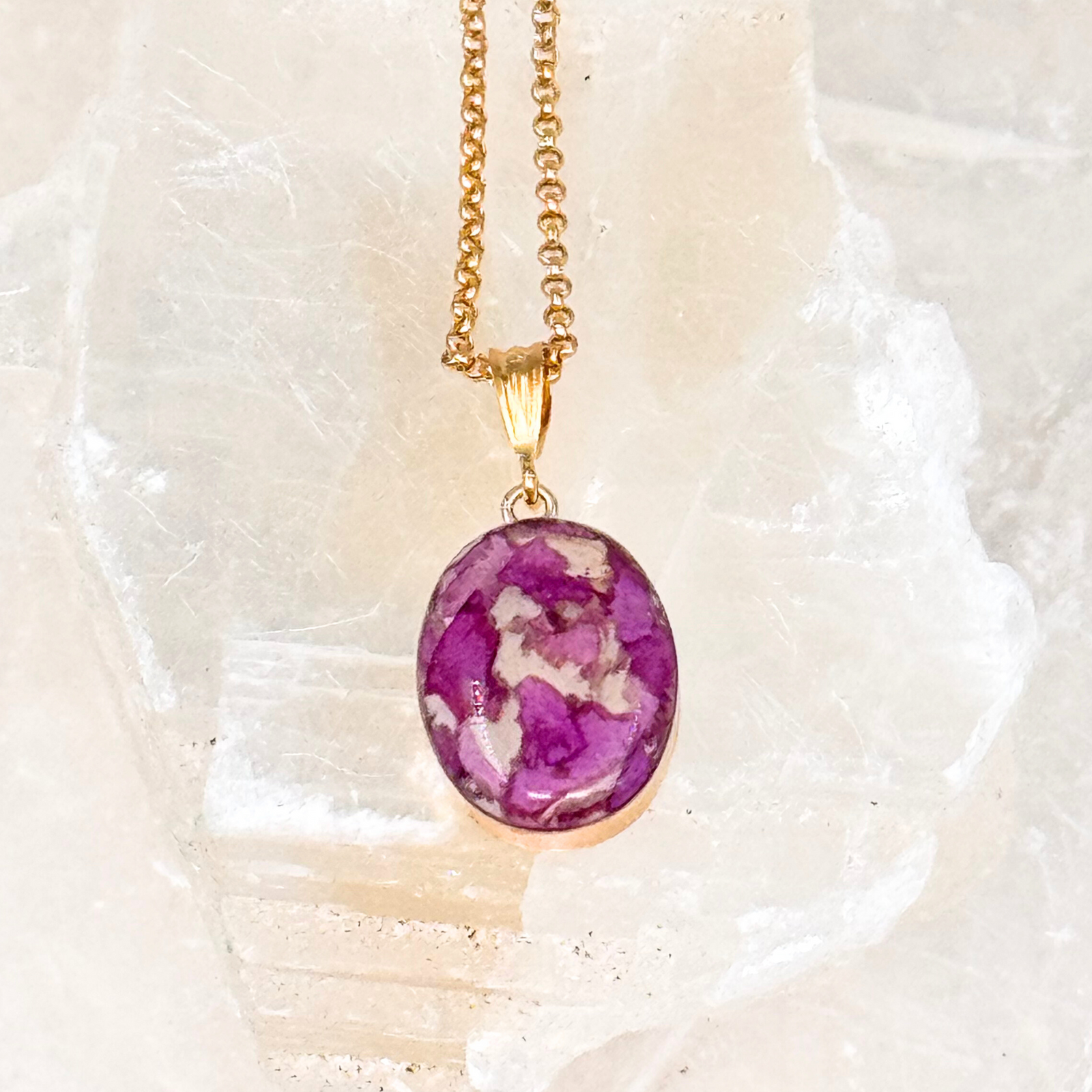 Gold-plated oval pendant featuring preserved purple flower petals set in clear resin. A unique and elegant memorial necklace designed to hold cherished floral memories.