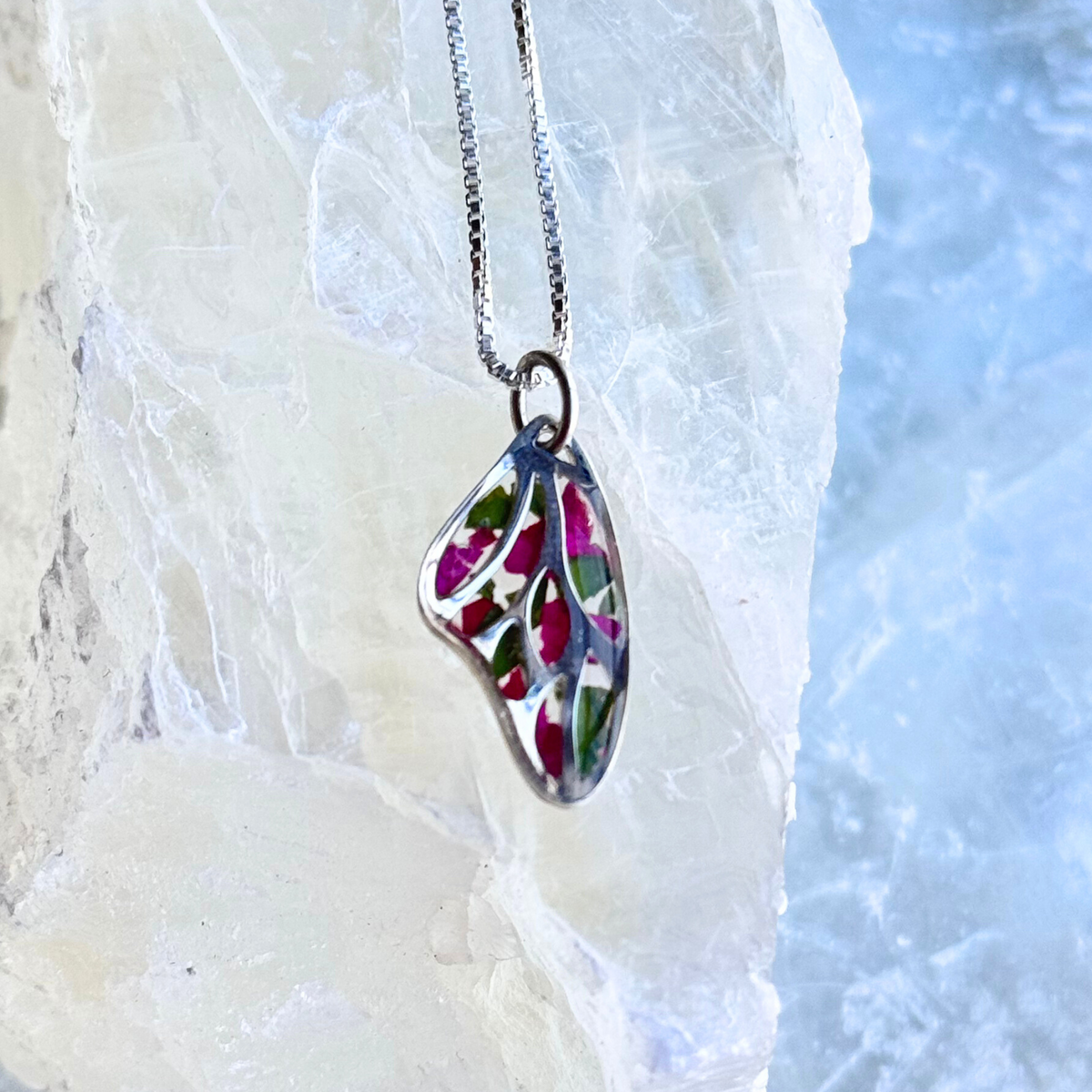 Custom butterfly wing pendant crafted with real preserved flowers from a funeral arrangement, a timeless piece of keepsake jewelry.