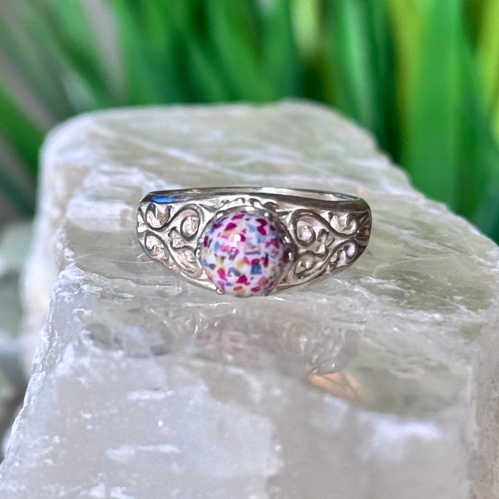 A detailed close-up of the Scrollwork Memorial Ring, featuring a handcrafted stone infused with preserved funeral flowers. The intricate silver scrollwork complements this meaningful memorial jewelry piece, symbolizing love and remembrance.