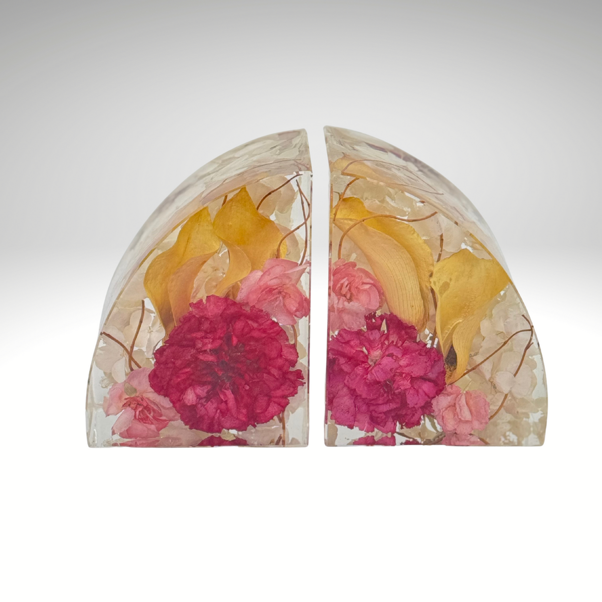 A front-facing view of The Keepsake Hold resin bookends with preserved pink and yellow flowers. A handcrafted memorial or wedding keepsake.