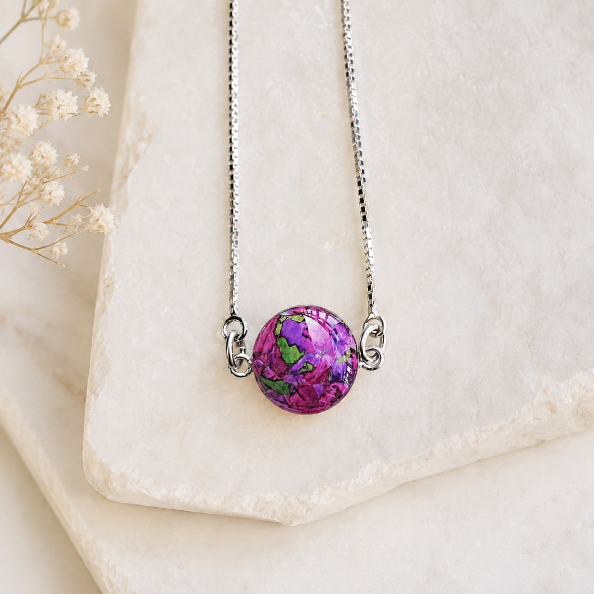 Close-up of the Timeless Blossom Bracelet handcrafted in sterling silver with a preserved flower centerpiece and adjustable slider chain. Custom memorial bracelet made with wedding flowers, funeral flowers, ashes, or pet fur.