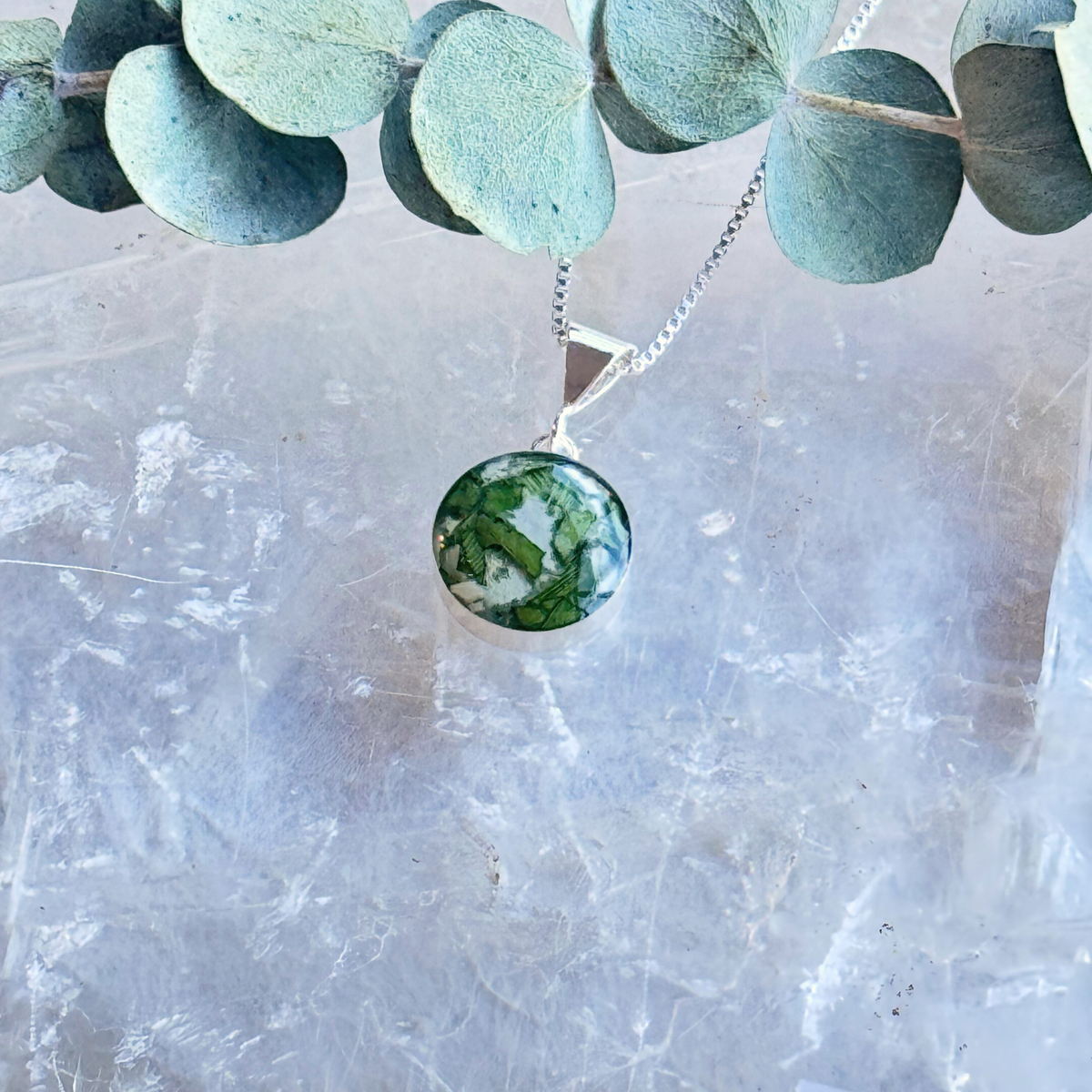 Close-up of the Timeless Blossom Pendant highlighting the intricate details of the preserved flowers.