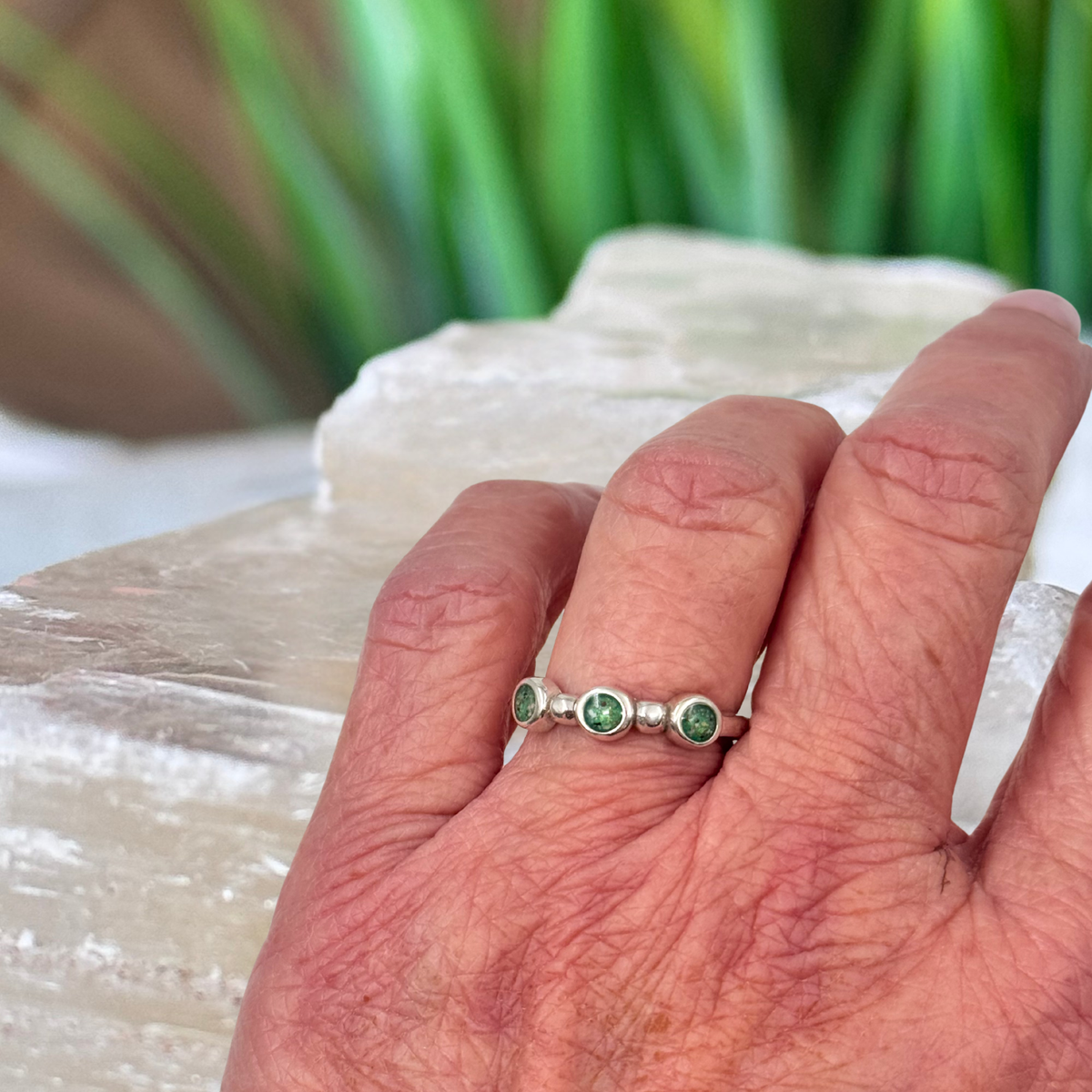 Trinity Keepsake Ring worn on hand, featuring three personalized keepsake settings created with cremation ashes in sterling silver.