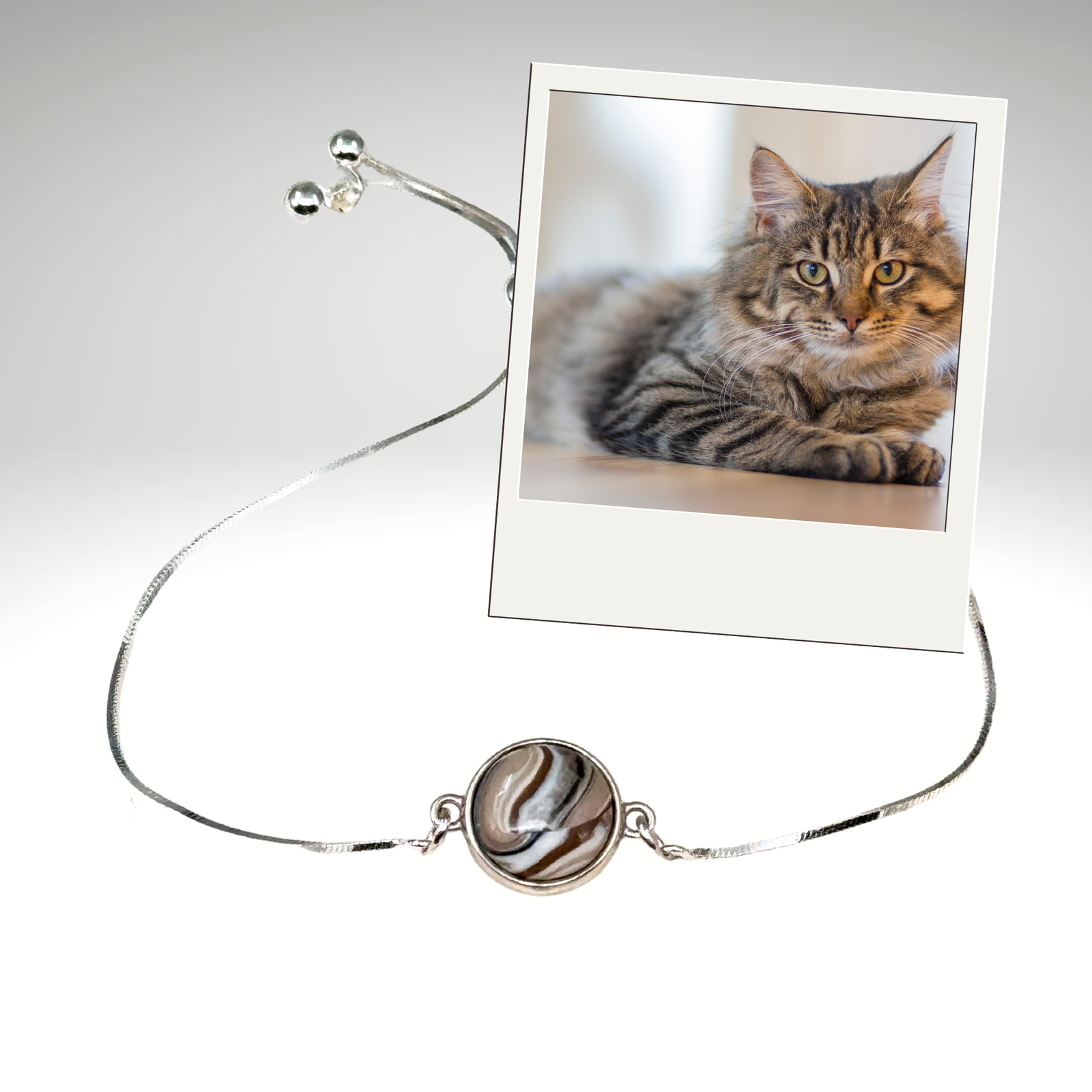 Sterling silver double-sided pet memorial bracelet featuring a custom design made with cat fur and pet resemblance, displayed beside a tabby cat.