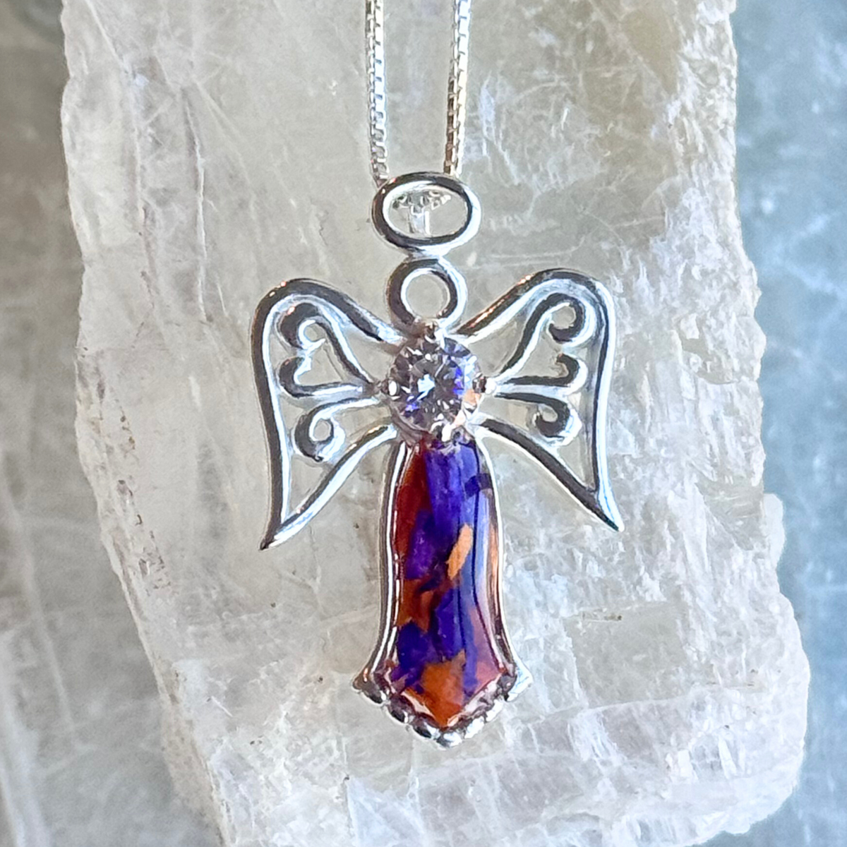 Close-up of the Wings of Light Pendant showcasing angelic details and floral inclusions