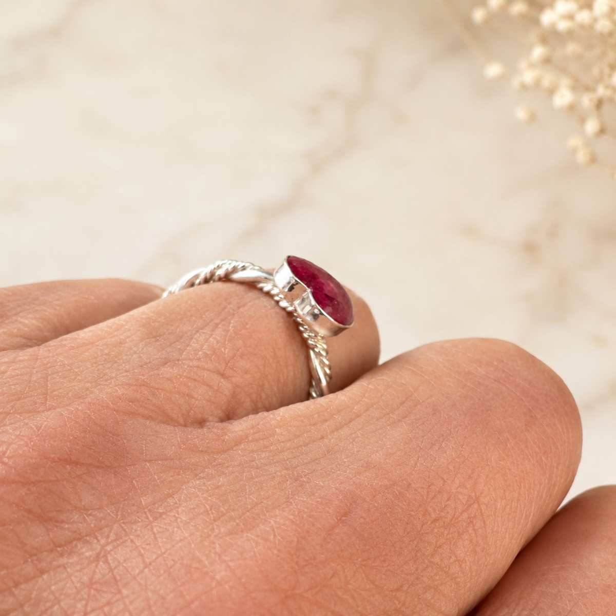 Model wearing Beloved Heart Keepsake Silver Ring with pink preserved flowers, shown from the side.