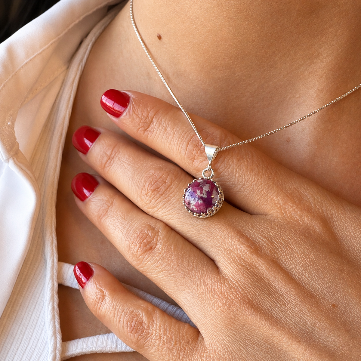 Model wearing Blossom of Memories Pendant with purple and white preserved flowers.