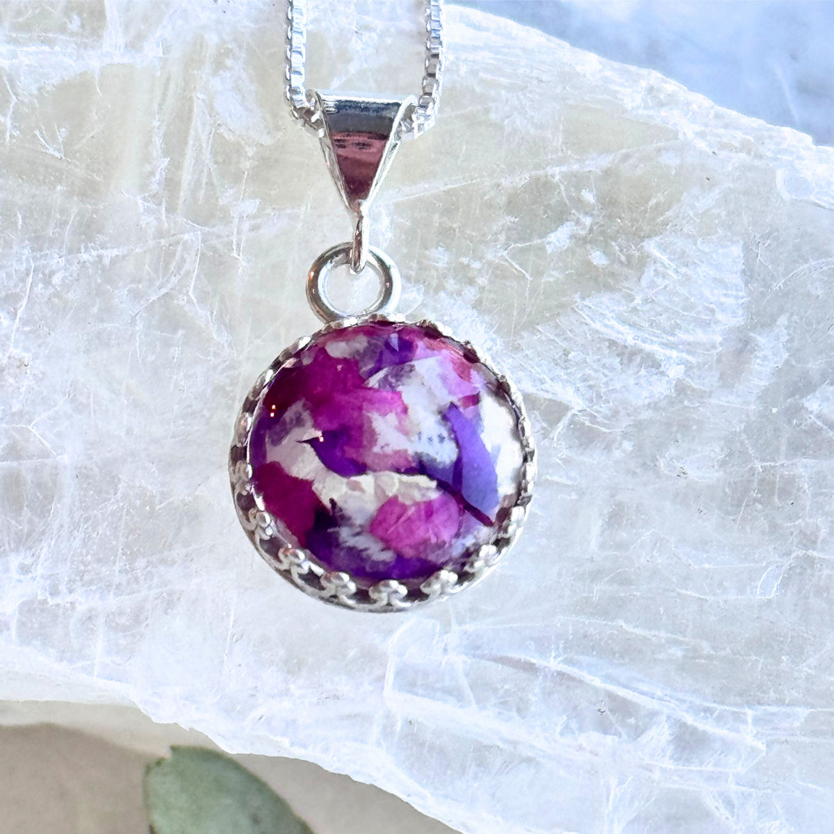 Blossom of Memories Pendant with purple and white preserved flowers.