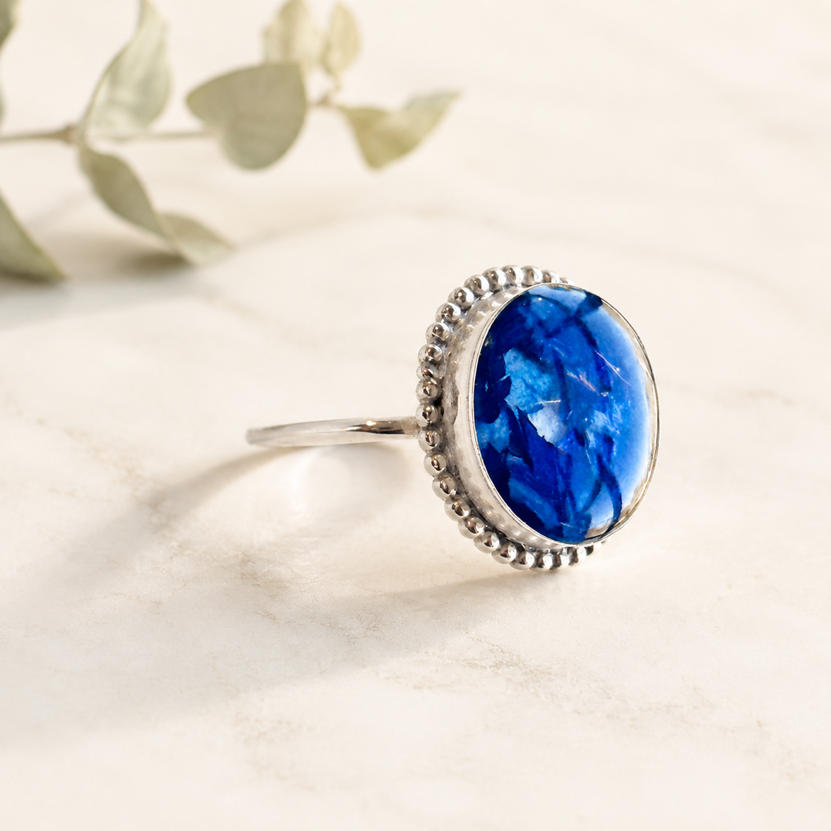 Circle of Memories Ring with blue preserved flowers in a silver setting.