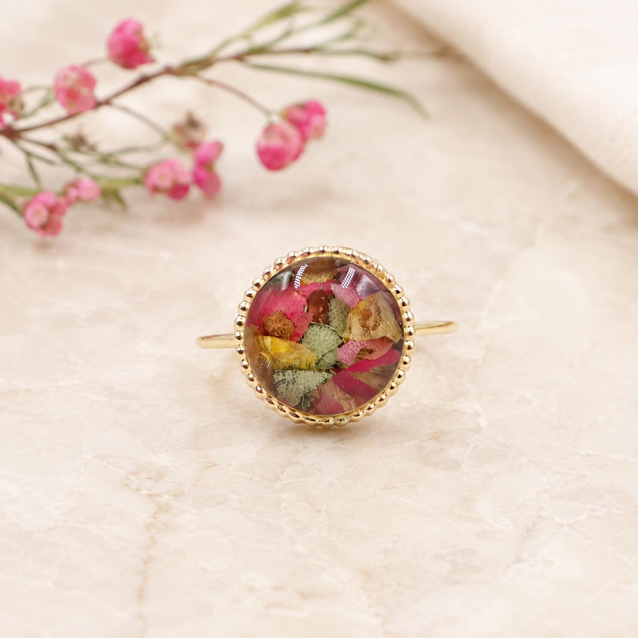 Circle of Memories Ring with pink and multicolor preserved flowers in a gold setting.