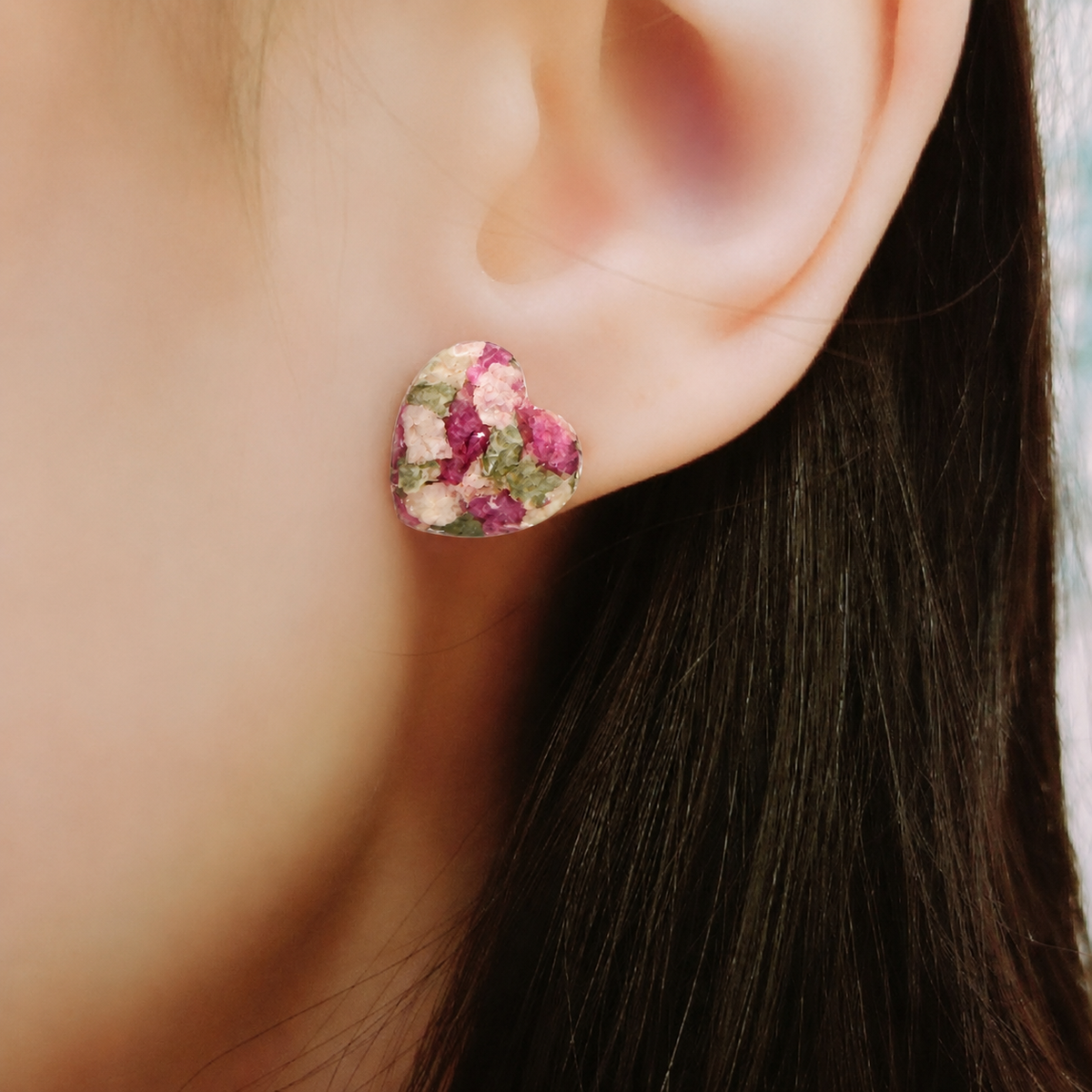 Model wearing Crystal Heart Memorial Post with pink, white and green preserved flowers.