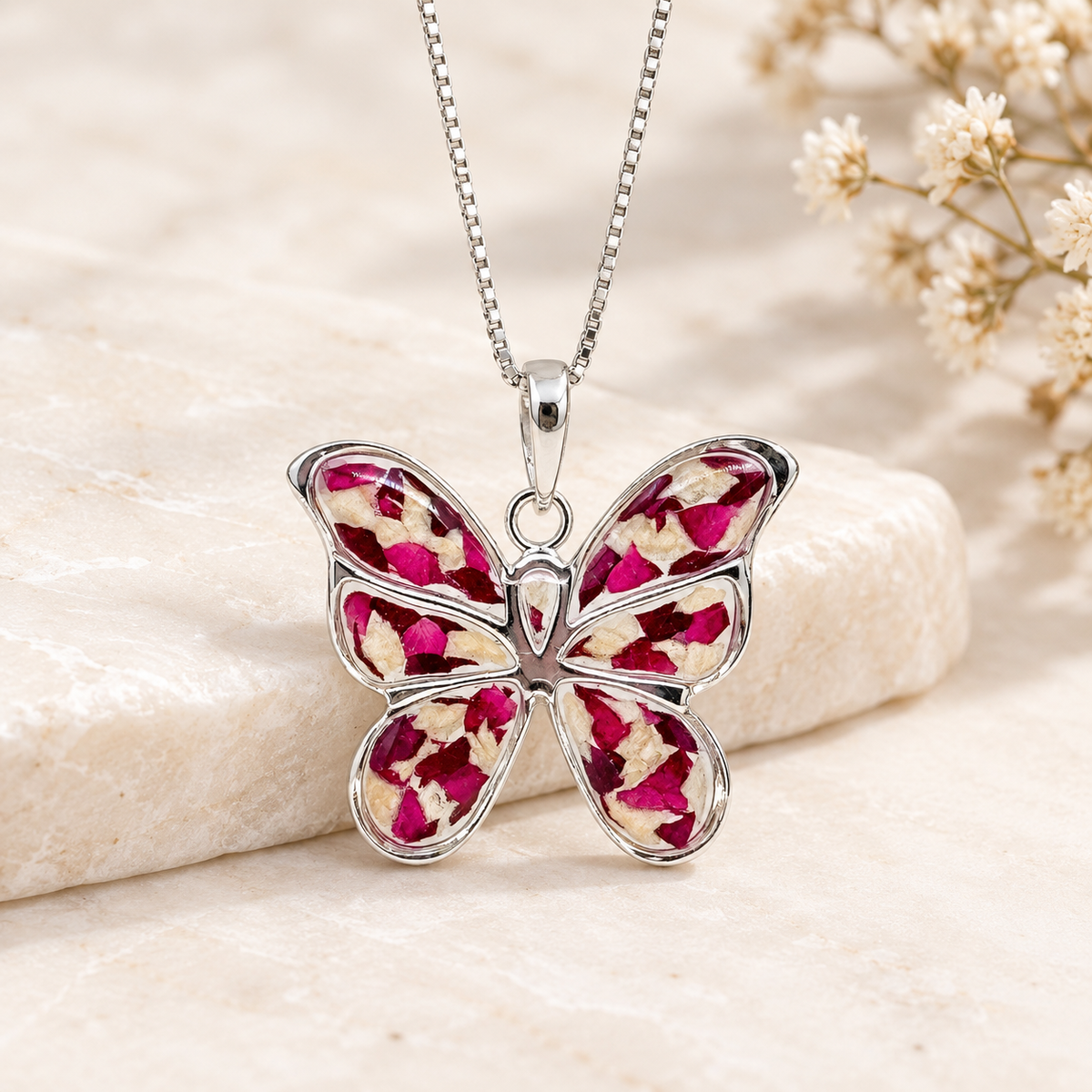 Sterling silver butterfly keepsake pendant with red, pink, and white preserved flowers.