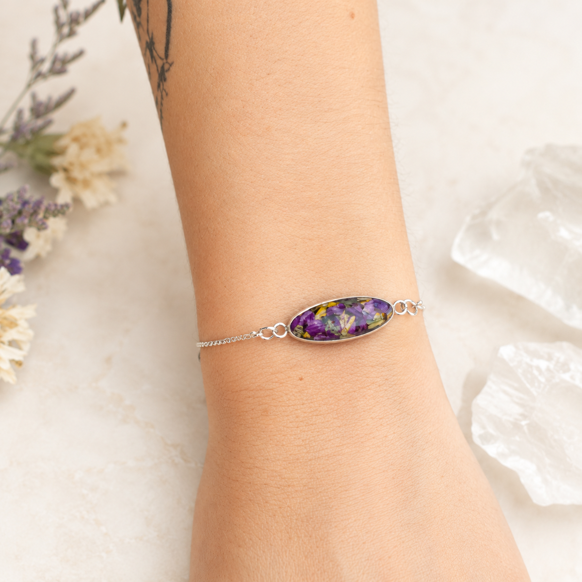 Eternal Grace Memorial Bracelet with purple and yellow preserved flowers worn on the wrist.