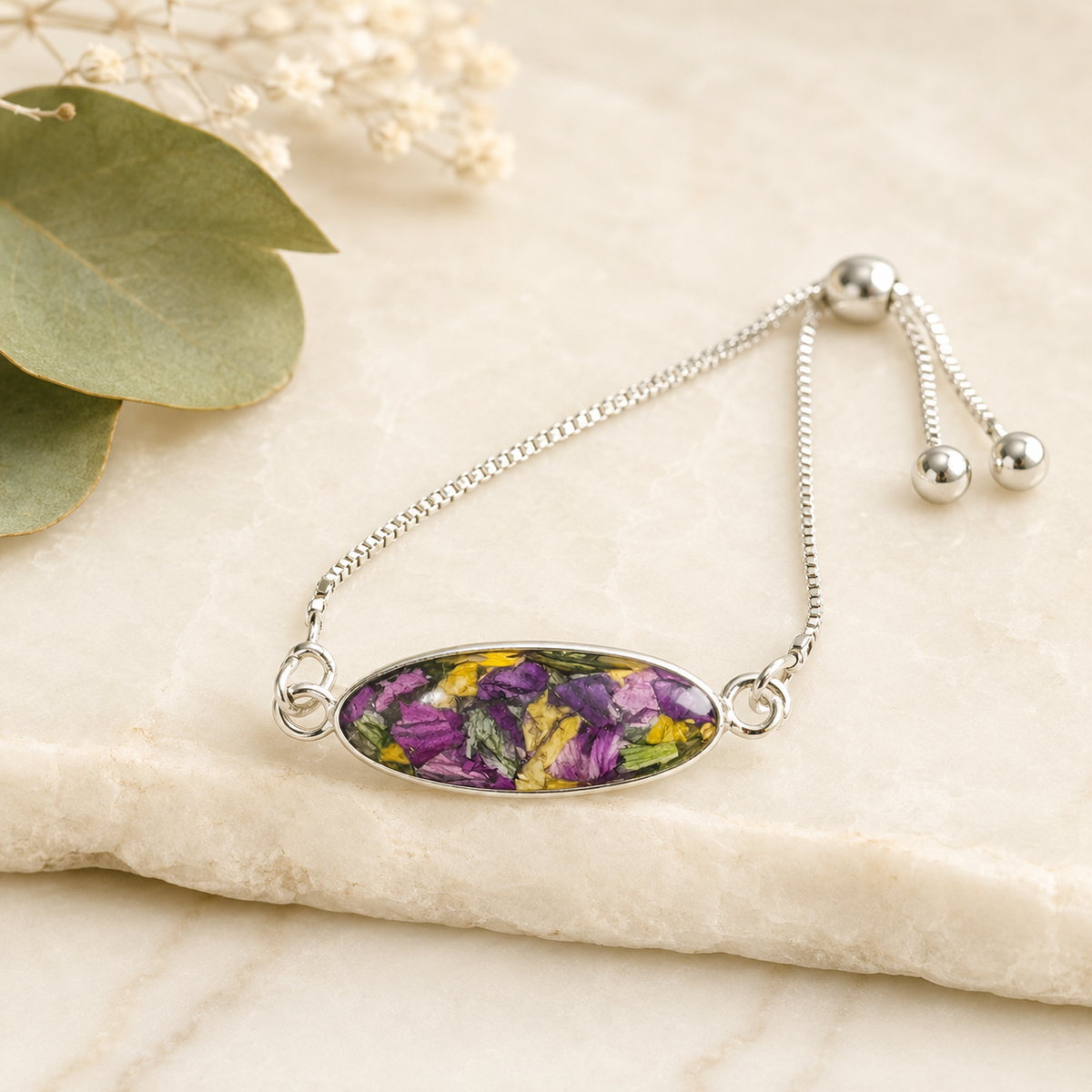 Eternal Grace Memorial Bracelet with purple, yellow and green preserved flowers in a silver setting.